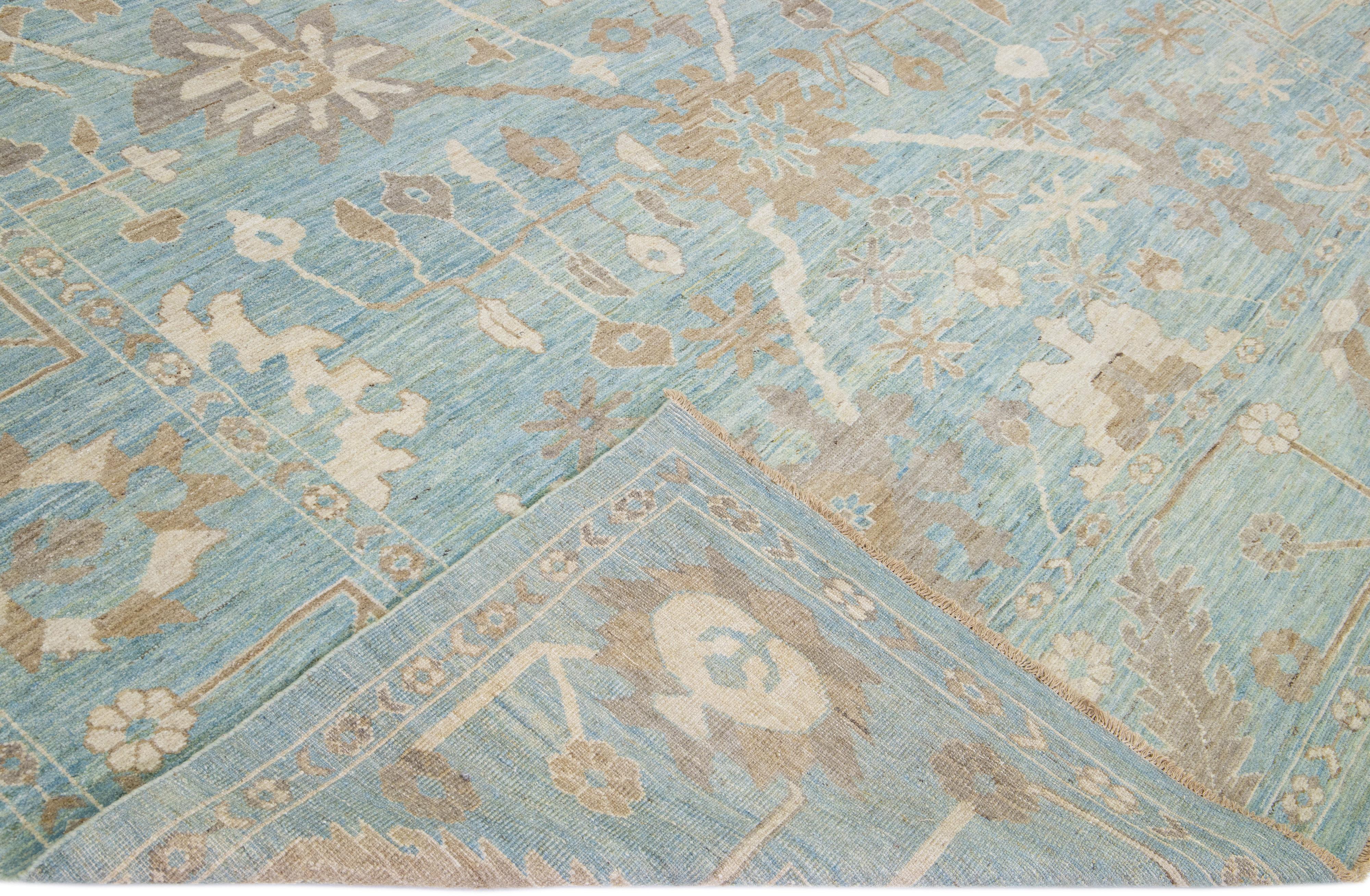 Preciosa alfombra moderna de lana anudada a mano Sultanabad Rugs con campo azul. Esta alfombra Sultanabad tiene detalles en marfil y marrón en un precioso diseño floral clásico integral.

Esta alfombra mide 10'7
