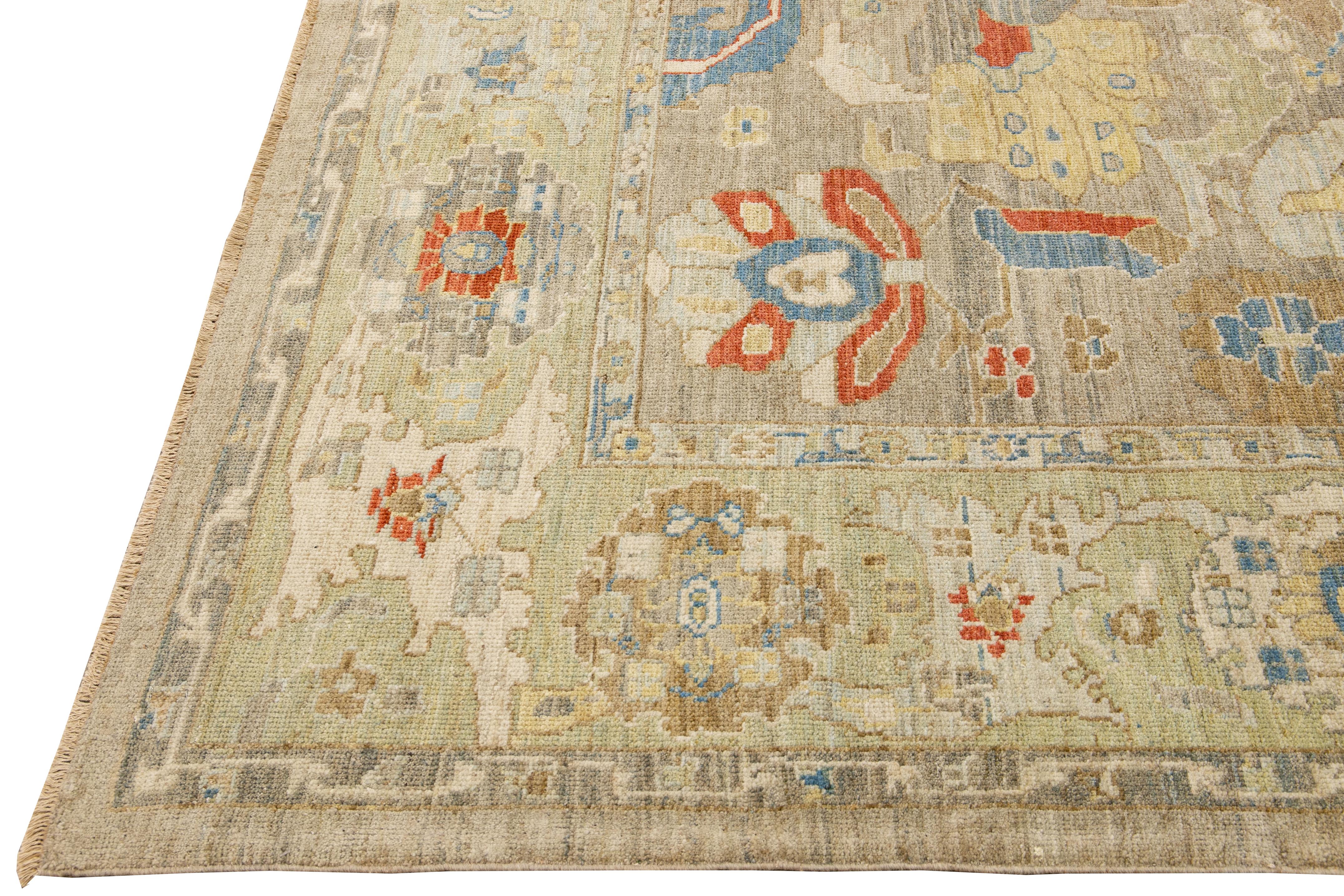 This stunning, hand-knotted Sultanabad rug features a modern design with a light brown base. The Persian rug is bordered with a green frame and embellished with many colors that form an attractive floral pattern.

This rug measures 10'4