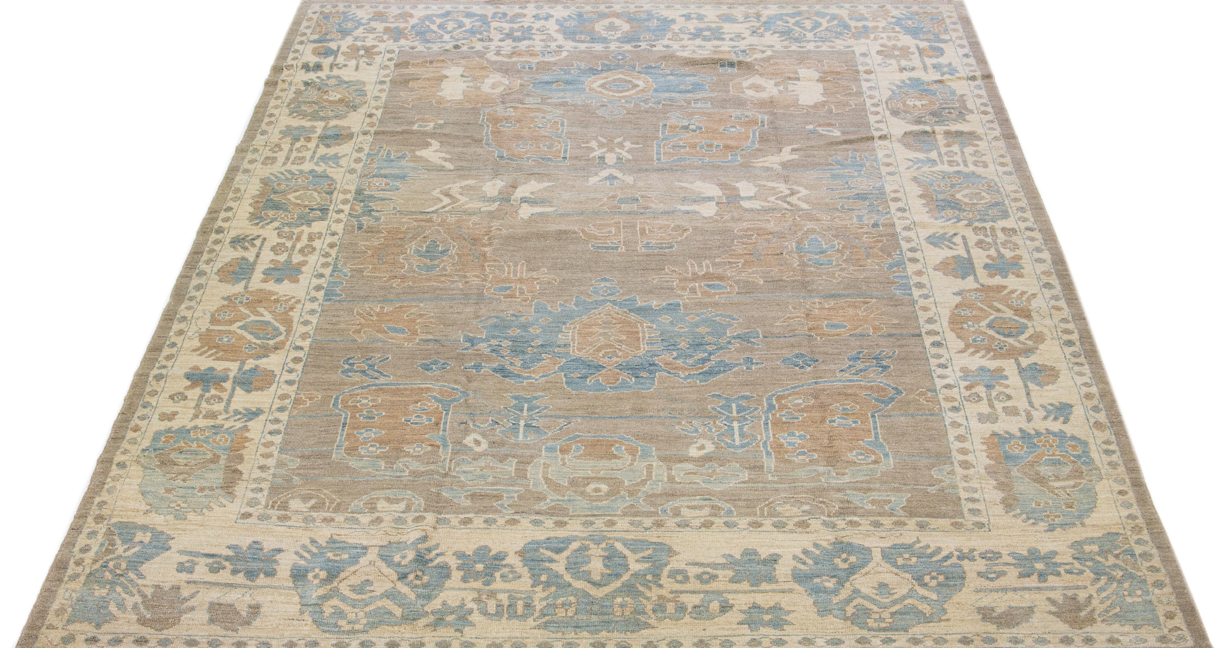 Beautiful modern Sultanabad hand-knotted wool rug with a light brown color field. This rug has blue accents in a gorgeous all-over floral design.

This rug measures: 10'4