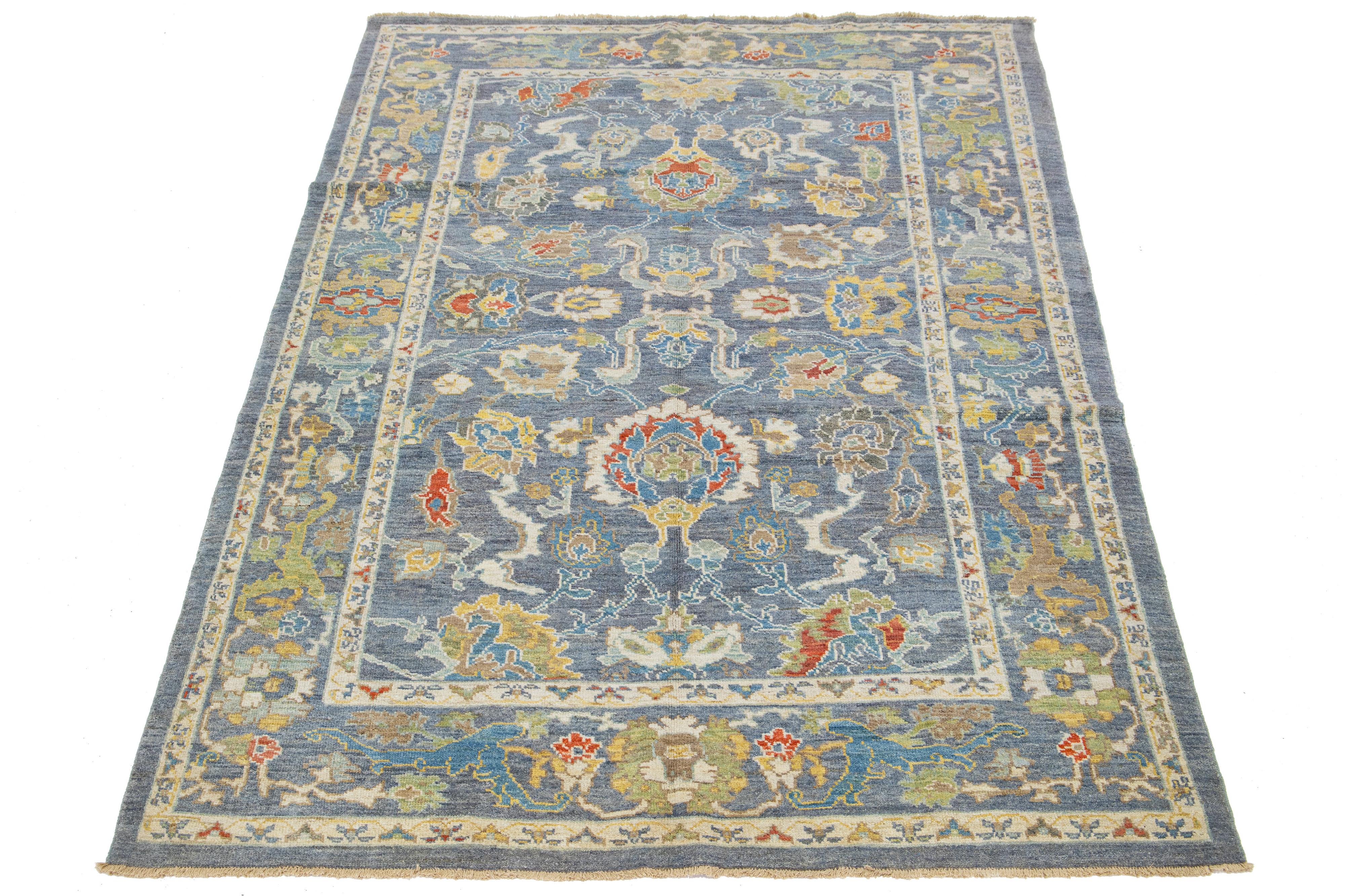 This hand-knotted Sultanabad rug features a modern design with a blue base. The Persian rug is bordered with a beige frame and embellished with many colors that form an attractive floral pattern.

This rug measures 6'7