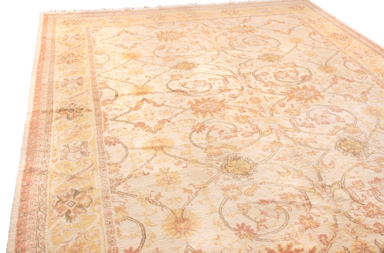 Originating from Nepal, this transitional wool rug features a unique modern pattern, combining European sensibilities with an antique Sultanabad design. Hand knotted in durable, tight wool, the swooping vine scroll and palmette patterns throughout