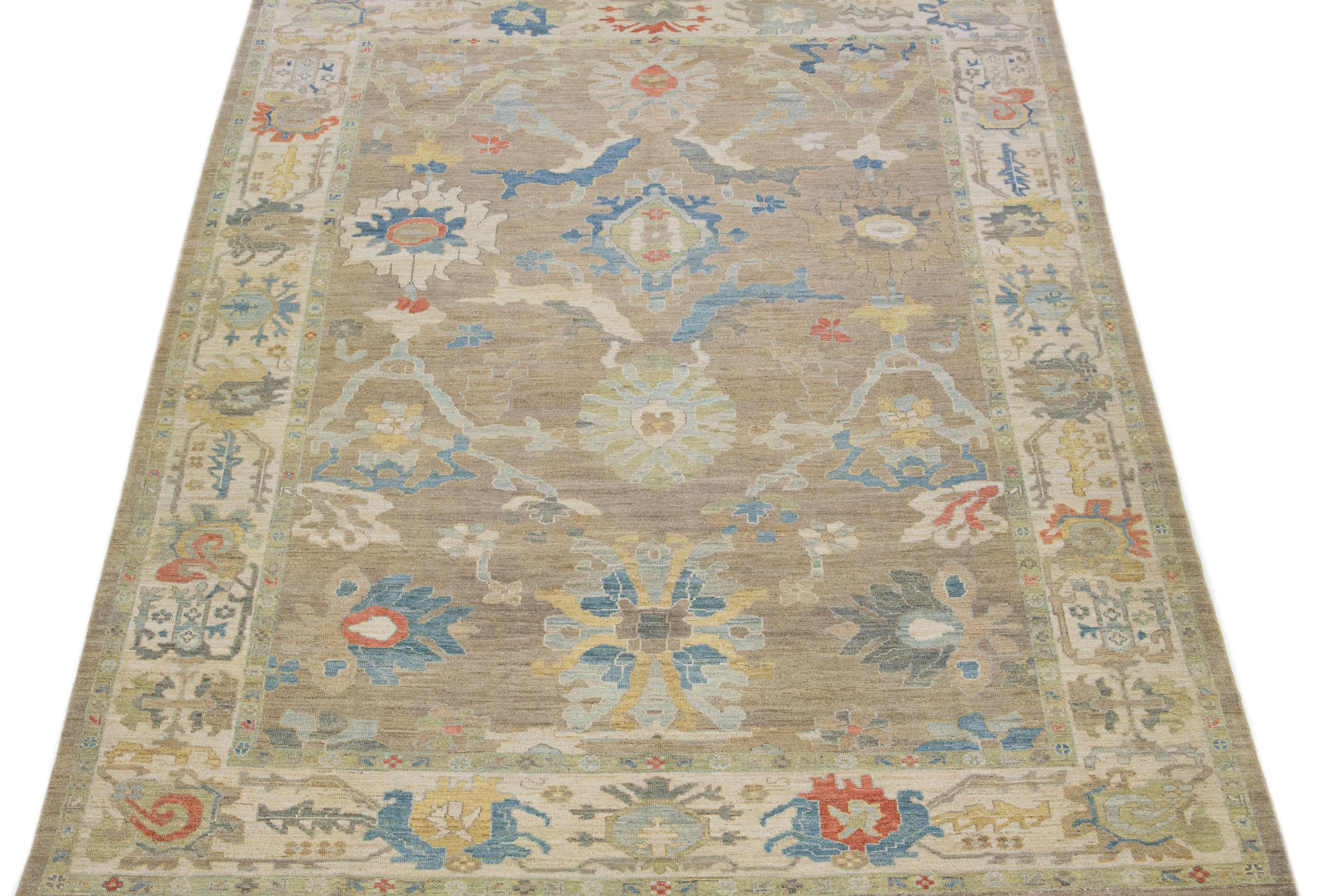 This contemporary take on the traditional Sultanabad style is showcased in an exquisite hand-knotted wool rug with a striking tan color. An intricately designed beige frame accentuates its all-over floral motif, adorned with multicolored accents