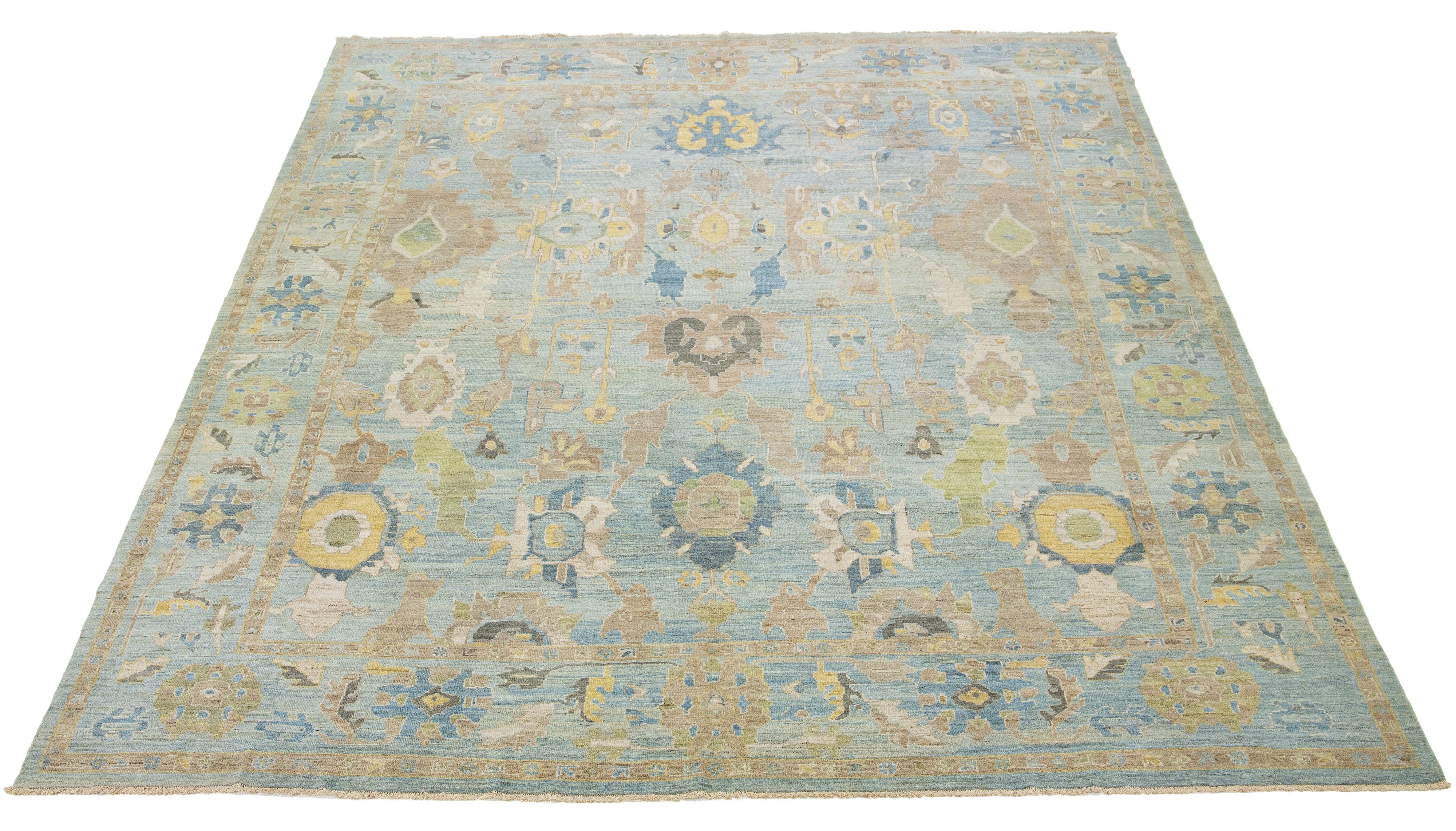 Dieser handgeknüpfte Wollteppich hat einen hellblauen Hintergrund, der mit gelben, beigen und braunen Allover-Motiven verziert ist.

Dieser Teppich misst 13'1'' x 16'1''.