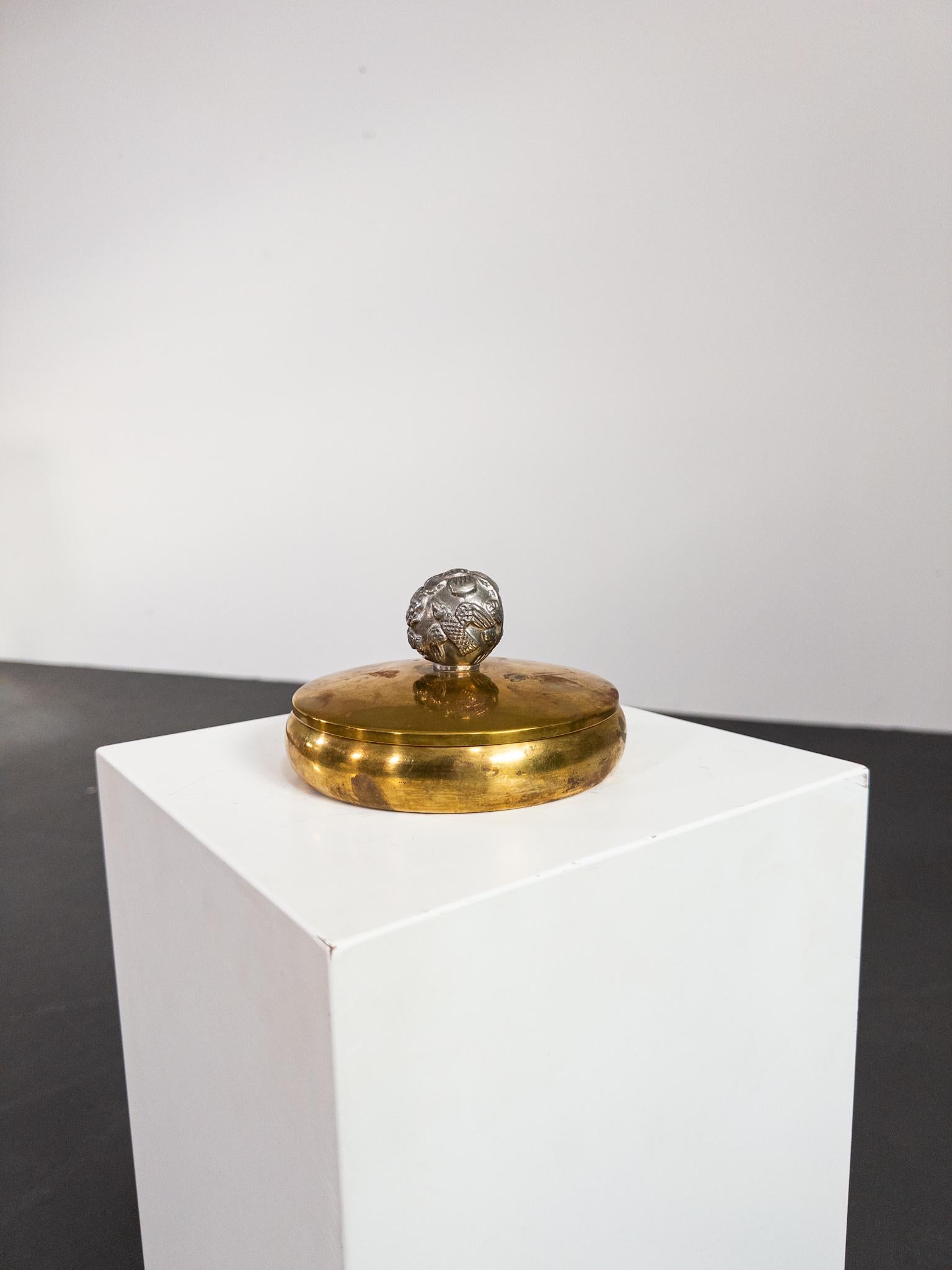 Questo raro cofanetto con coperchio è stato realizzato da Carl Einar Borgström per Ystad-Metall negli anni '30, un esempio di design moderno svedese. Realizzato in ottone massiccio, presenta una forma elegante e minimalista con una patina