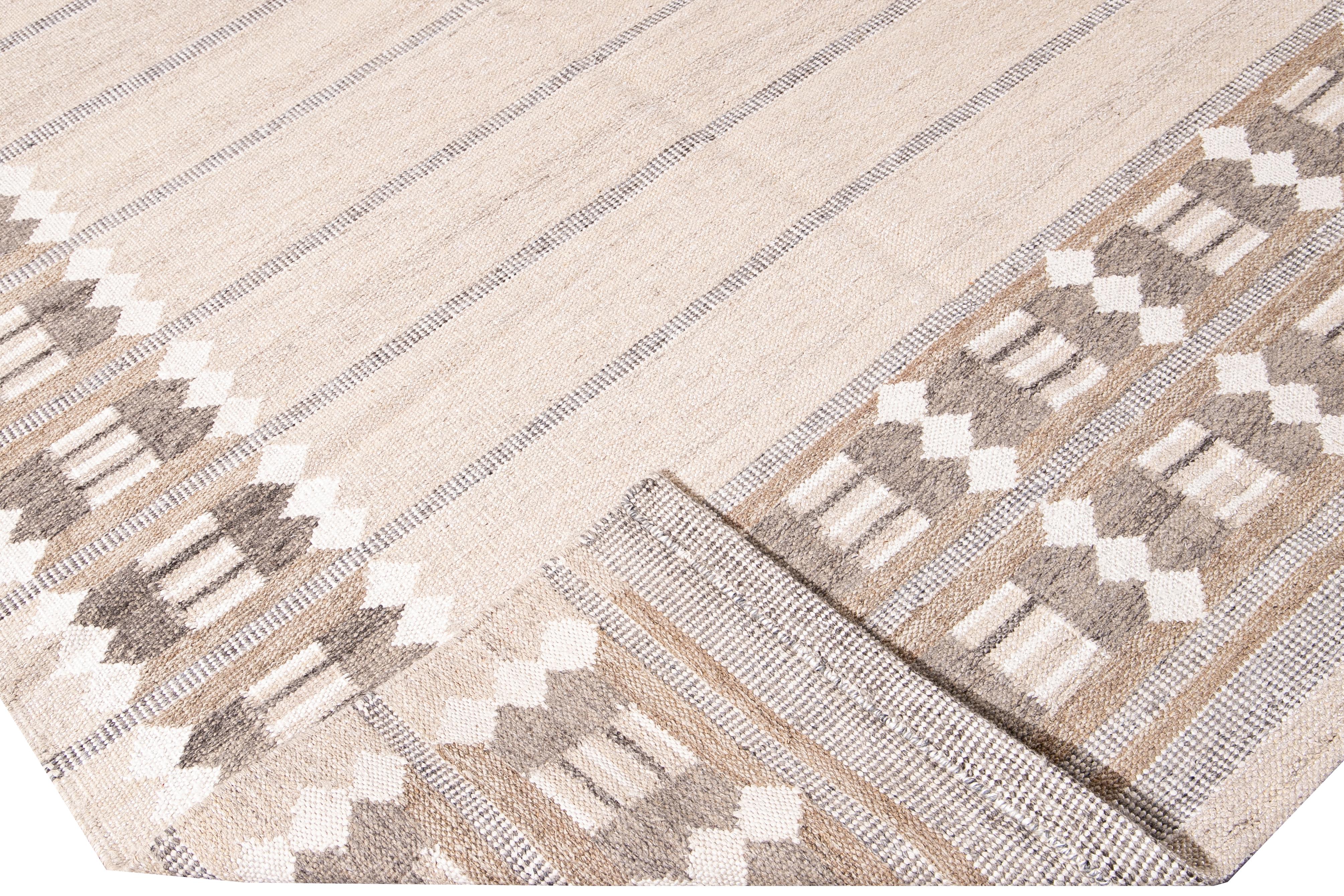 Beautiful modern oversize Swedish style wool rug with a solid beige field. This Swedish rug has accents of brown in a gorgeous all-over geometric frame design.

 This rug measures: 12' x 14'11