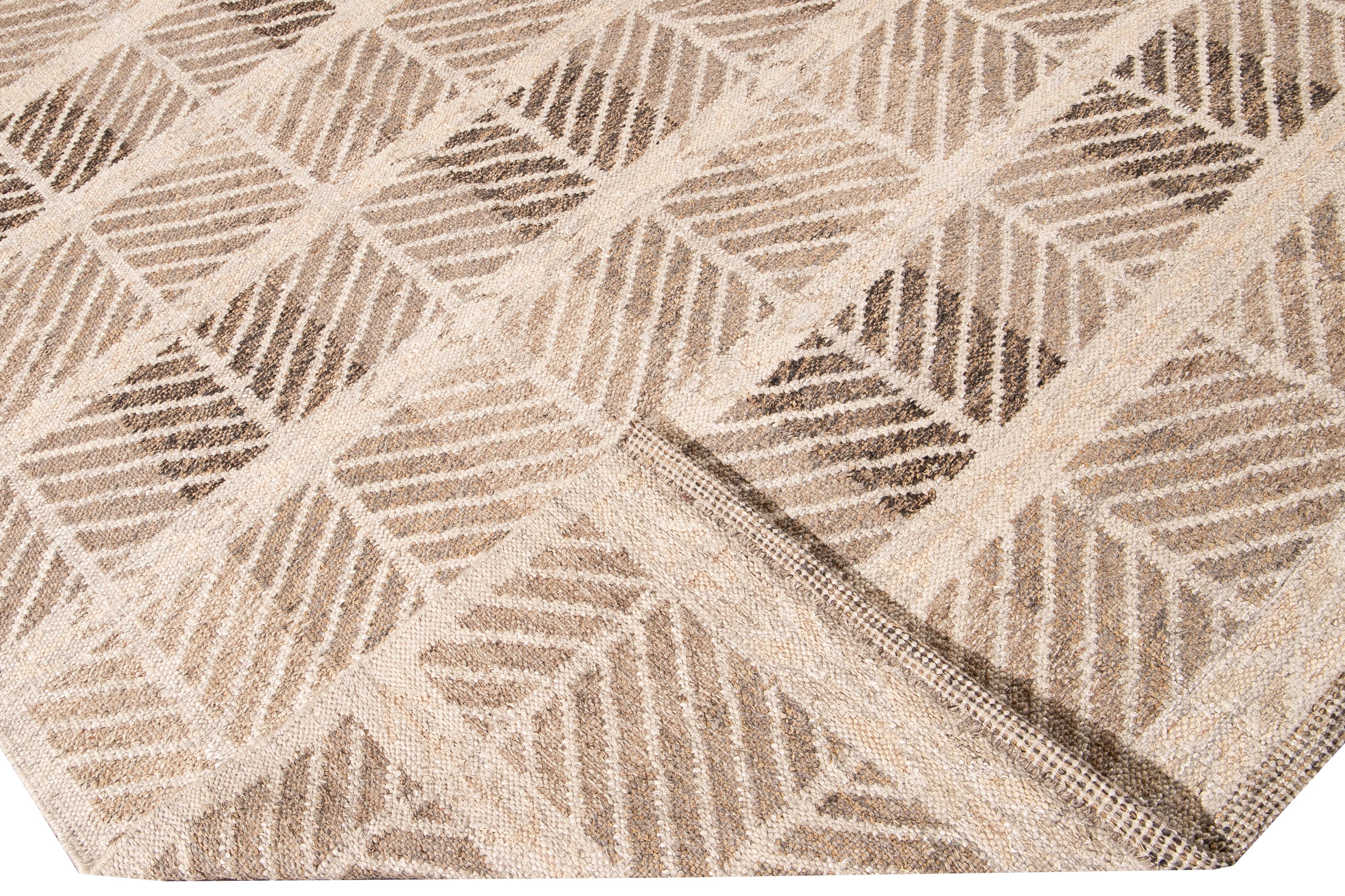 Bellissimo tappeto moderno oversize in lana in stile svedese con campo beige. Questo tappeto svedese presenta accenti di marrone in uno splendido disegno geometrico all-over.

 Questo tappeto misura: 12'4
