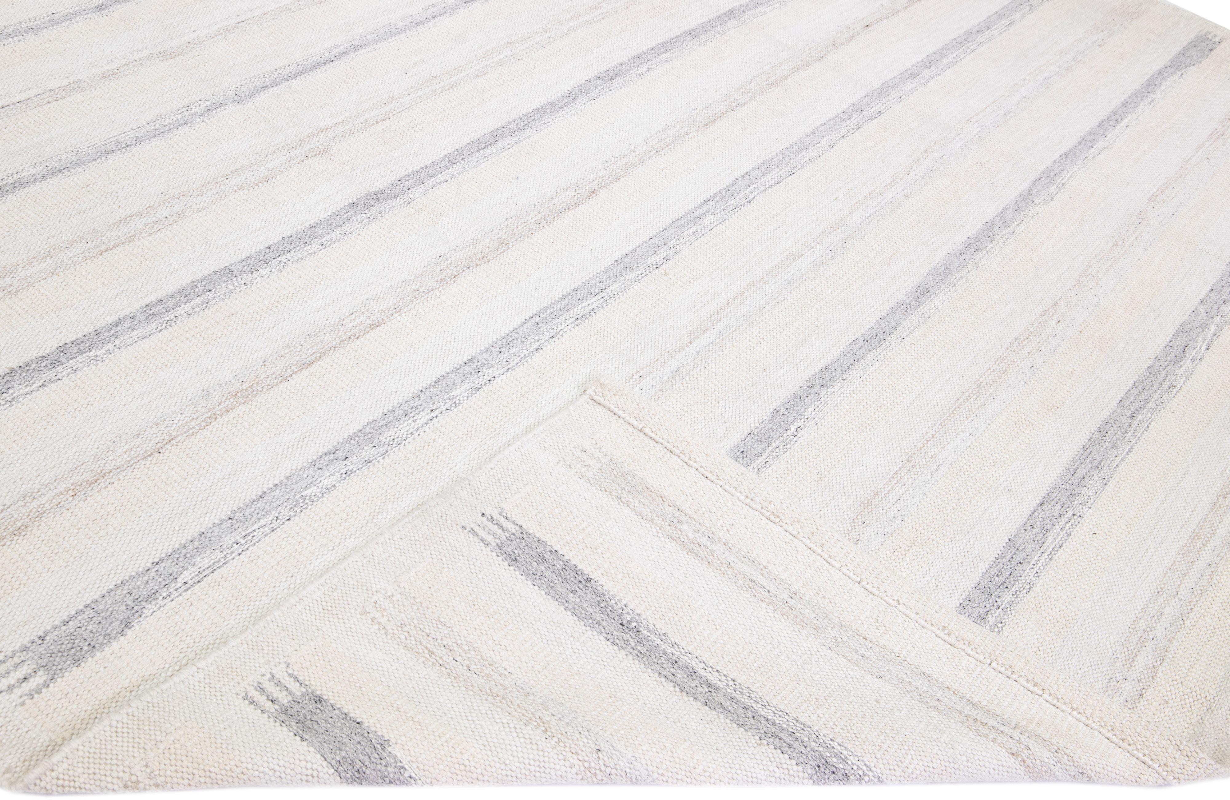 Beautiful modern Swedish-style wool rug with a gray and beige field. This piece has an ivory accent color featuring a gorgeous all-over geometric striped design.

 This rug measures: 12' x 15'2''.

Our rugs are professional cleaning before