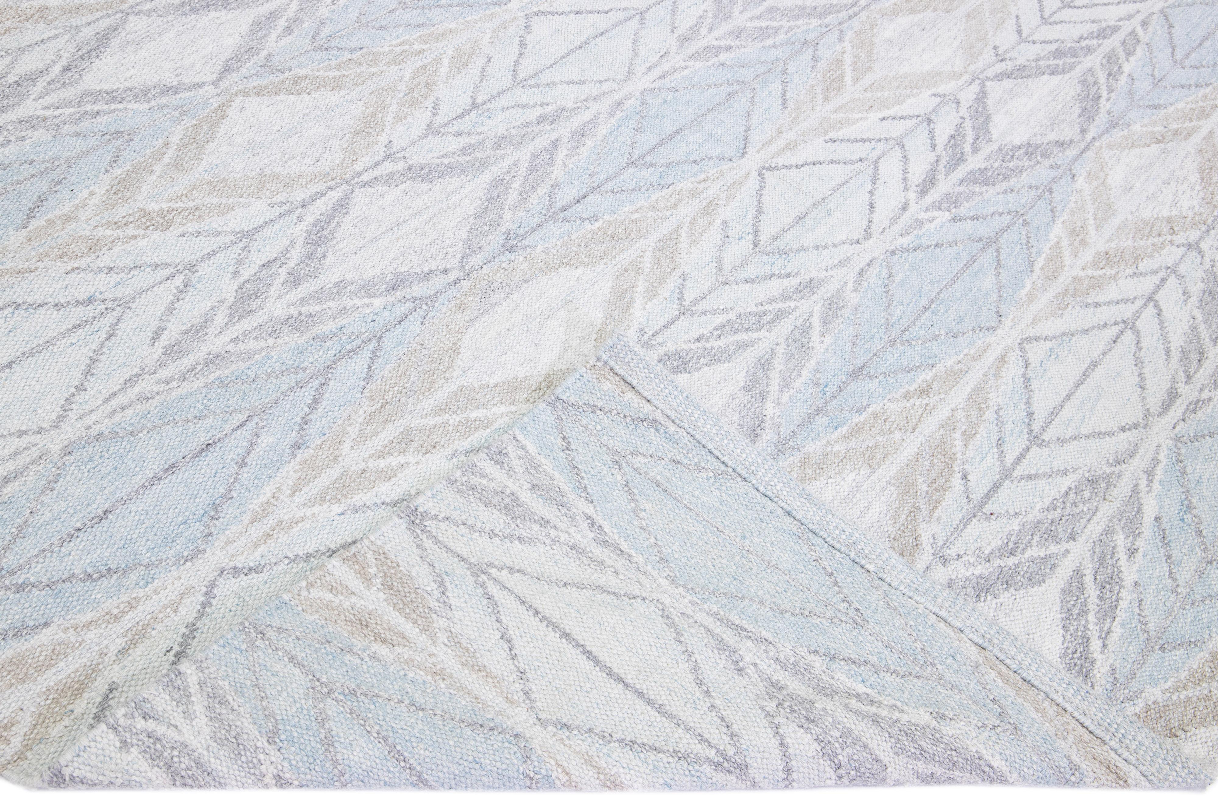 Beautiful modern Swedish-style wool rug with an ivory and blue field. This piece has gray accents featuring a gorgeous all-over geometric abstract design.

 This rug measures: 10' x 13'9''.

Our rugs are professional cleaning before shipping.