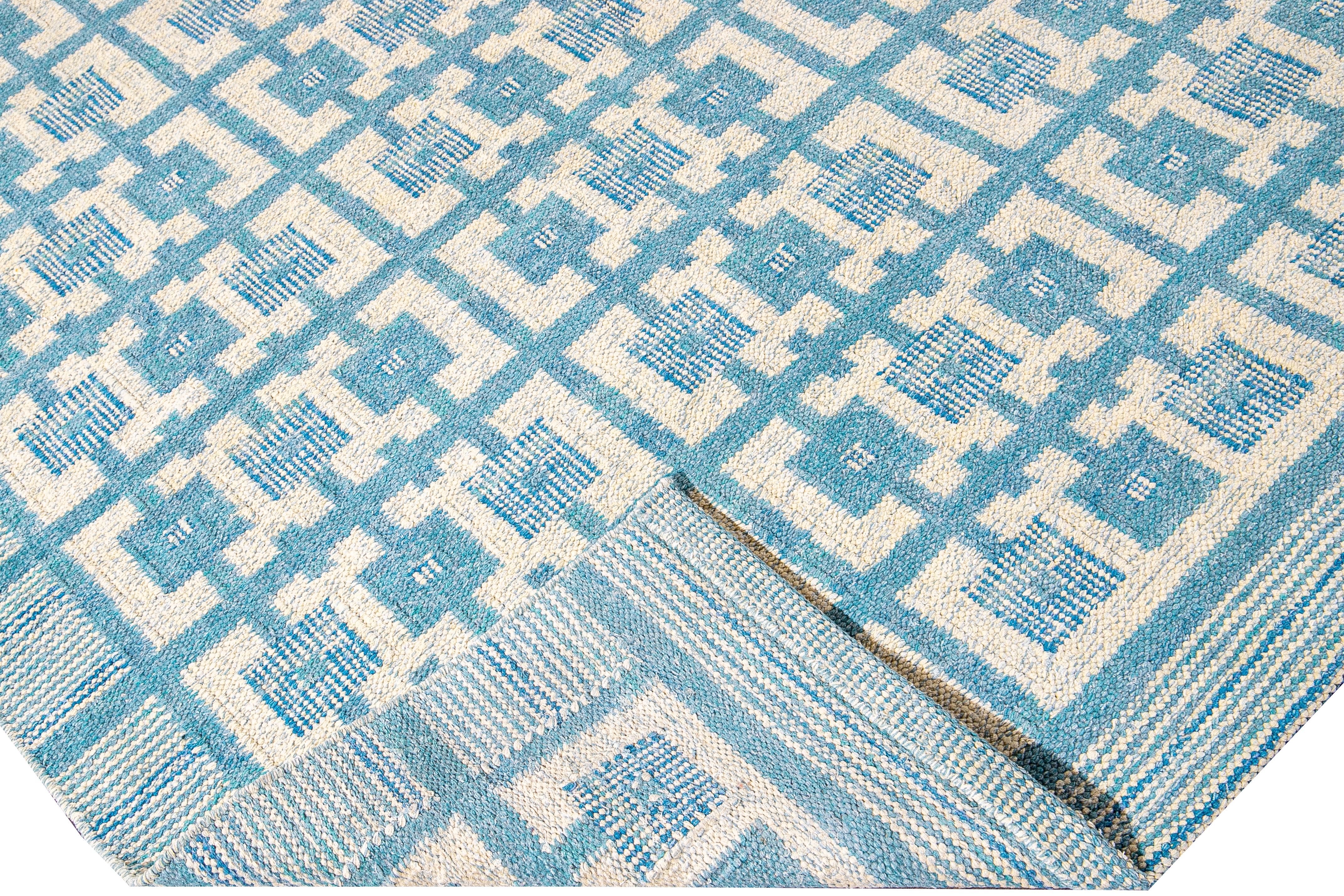 Bellissimo tappeto moderno oversize in lana in stile svedese con campo blu. Questo tappeto svedese presenta accenti di avorio in uno splendido disegno geometrico quadrato all-over.

 Questo tappeto misura: 12' x 14'9