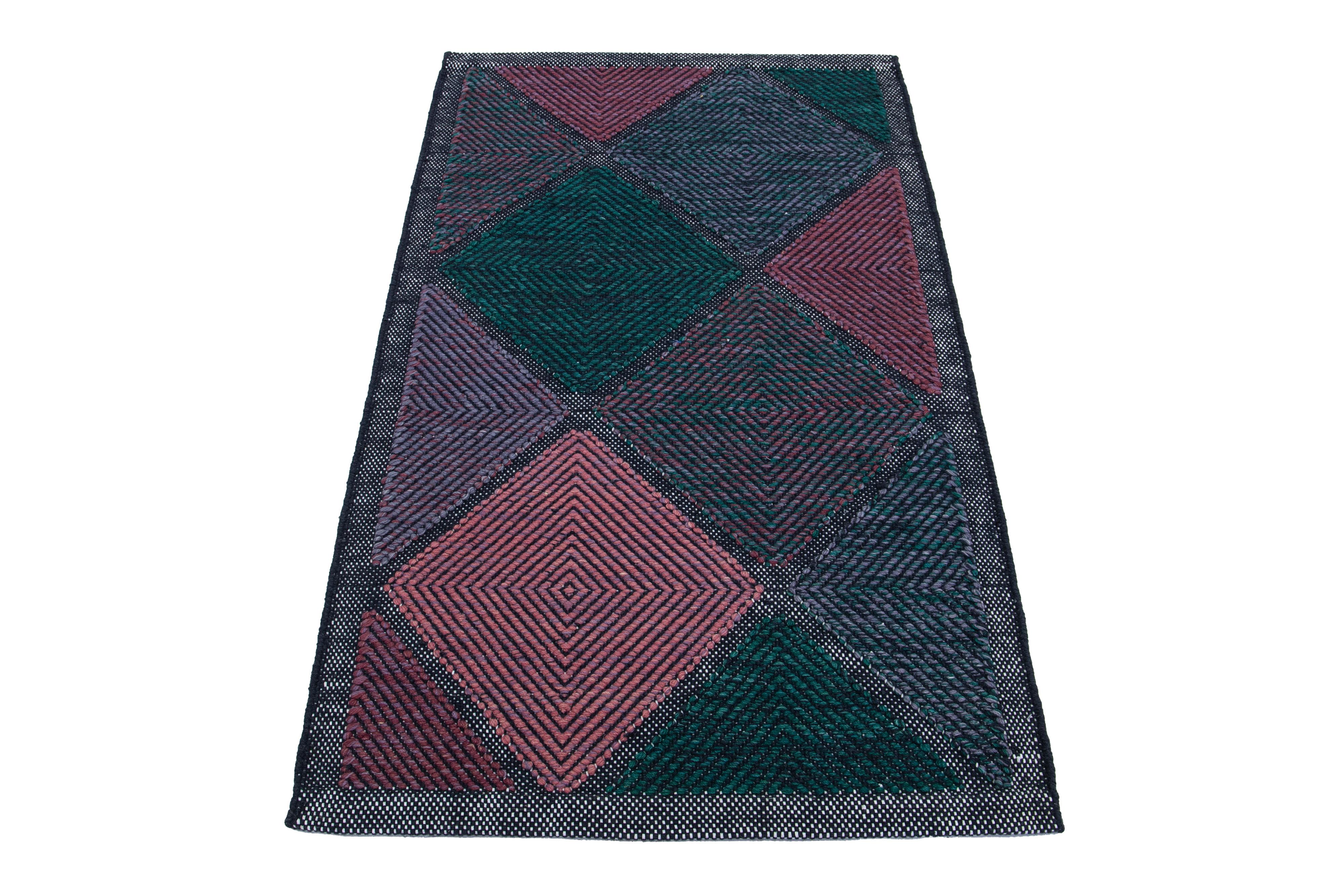 This flatweave rug showcases a contemporary Swedish design with a gray base. It's accented with green, purple, and pink geometric patterns throughout

 This rug measures 3'1