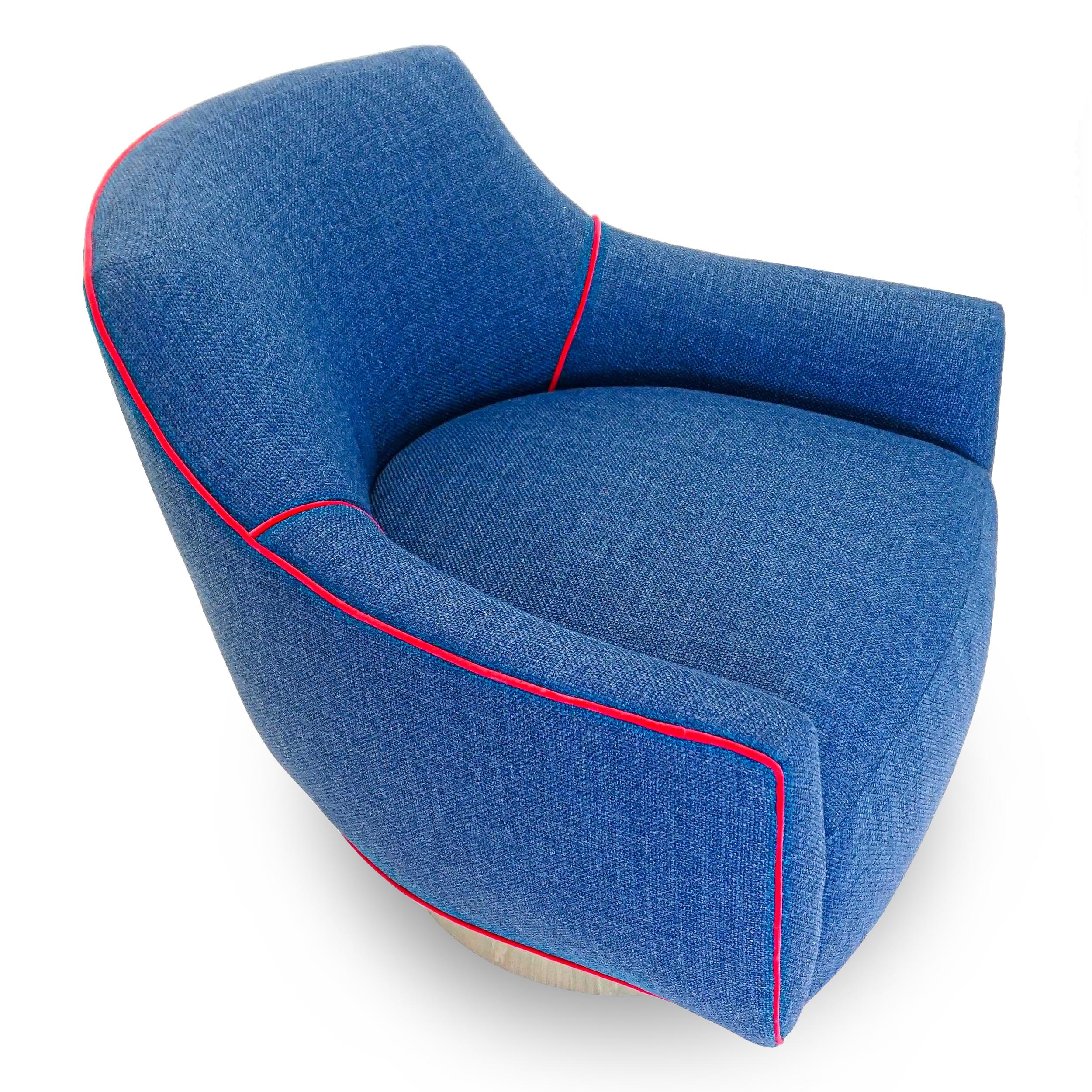 This modern swivel is covered in a soft chunky synthetic woven cobalt blue fabric by Scalamandre, accented with a fuchsia velvet welting.
Frame is solid hard maple. It has a tight seat and back cushion design with gently sloping winged arms. Seat