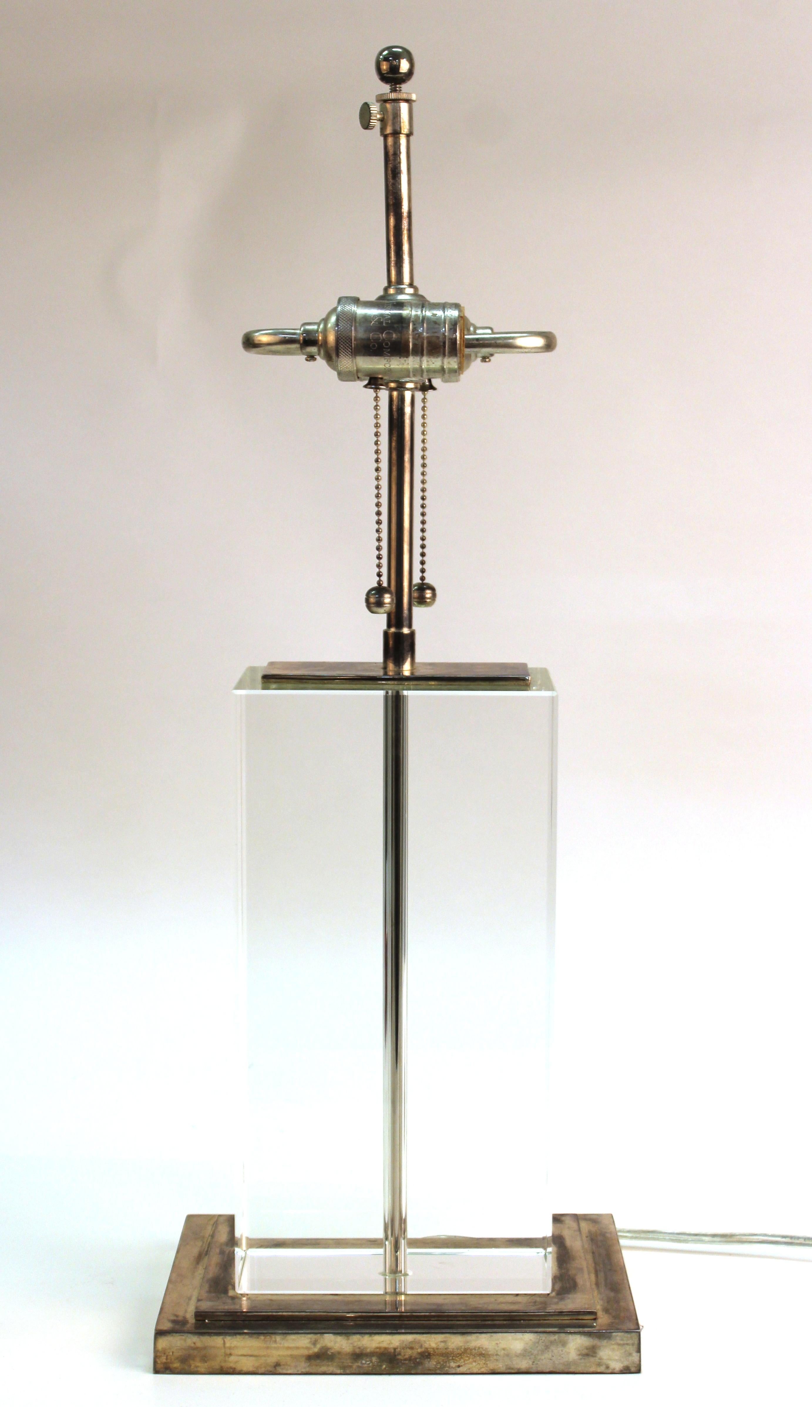 Modern table lamp composed of a heavy block of clear glass and chromed metal base and top. The piece has two light sockets and is in great vintage condition with age-appropriate wear and use.