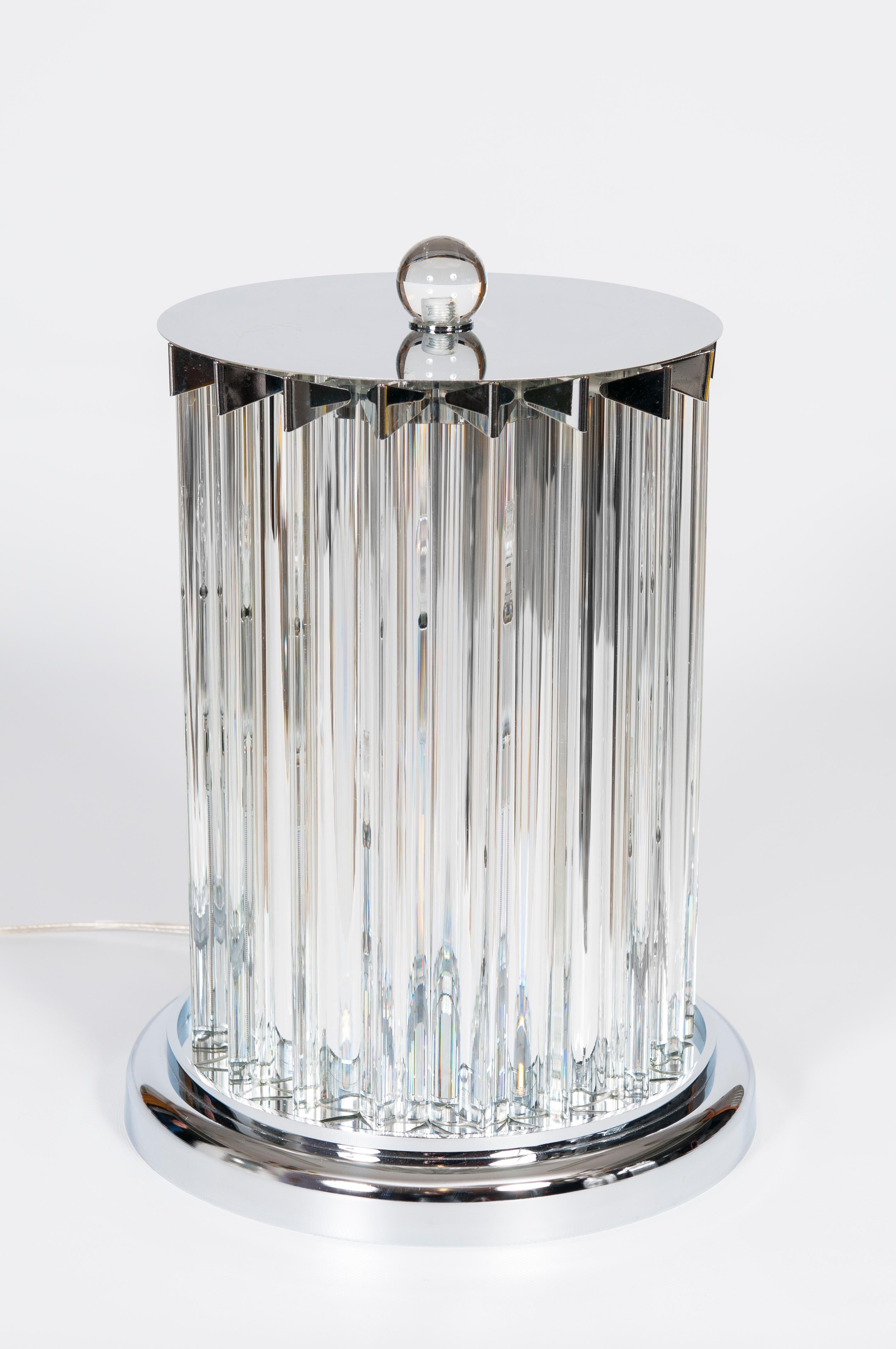 Lampe de table contemporaine en verre de Murano de couleur transparente, Giovanni Dalla Fina, 21ème siècle.
La lampe de table est composée d'éléments en verre transparent avec une base triangulaire qui reflètent la lumière des 2 ampoules centrales.