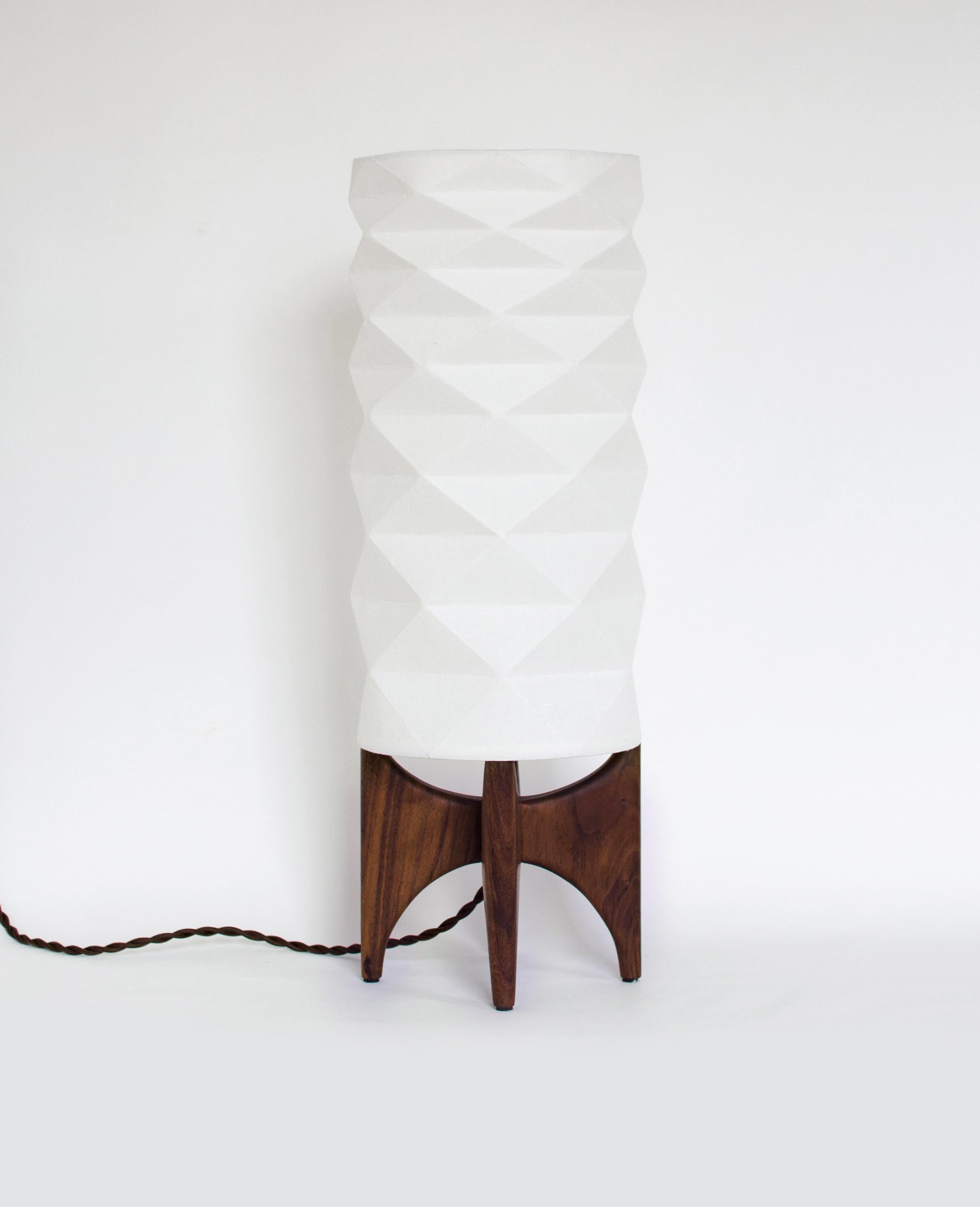 The TōRō lamp is a unique table lamp that will bring to your interior a modern-retro style functional piece. The origami-inspired lampshade is made of laminated linen fabric providing a bright, yet soft ambient light and showing the beautiful
