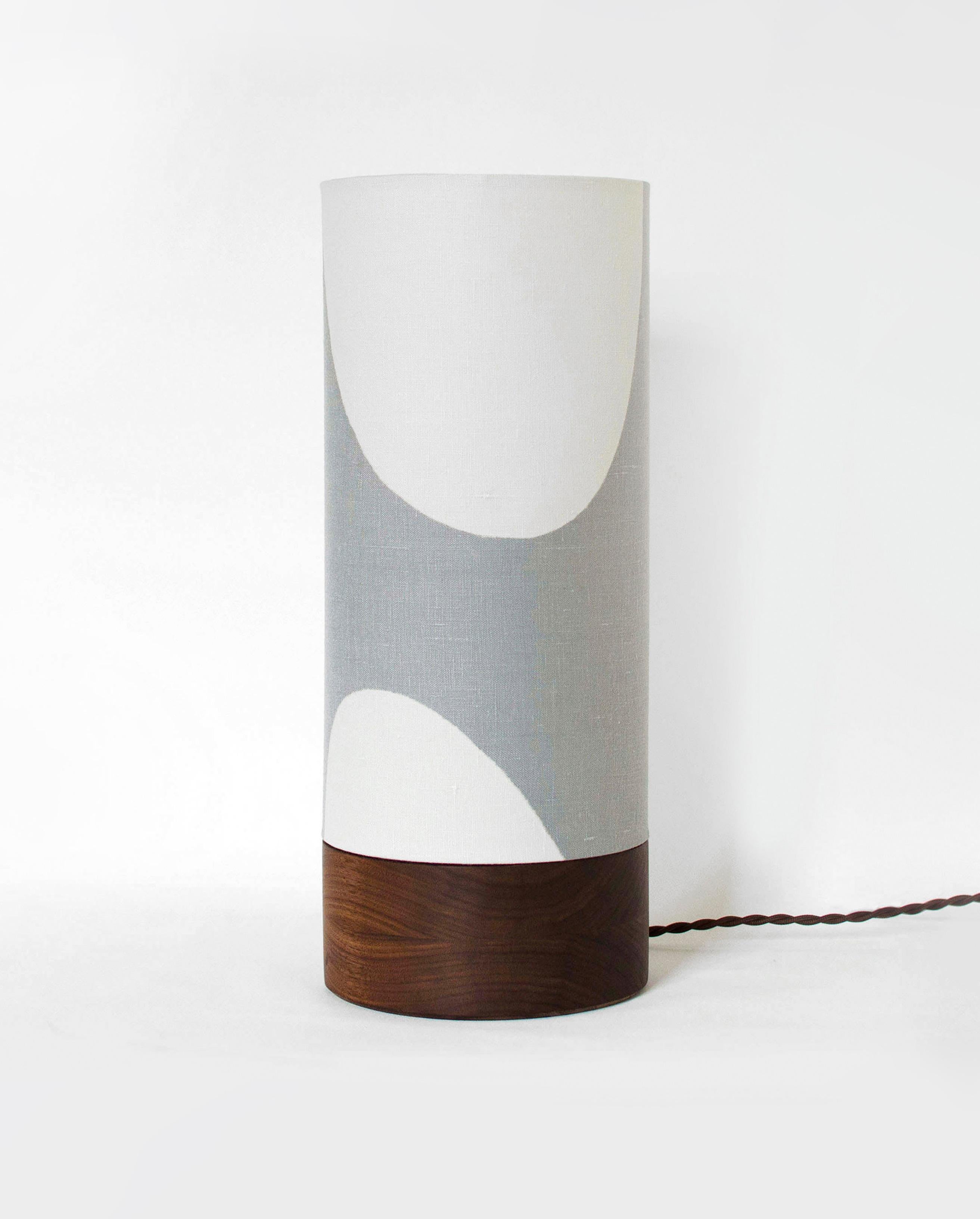 Exploring the balance between positive and negative spaces this table lamp evokes a Mid-Century aesthetic design with a contemporary look, bringing to any interior a handcrafted and unique piece. 

The lampshade is paired with a beautiful minimalist