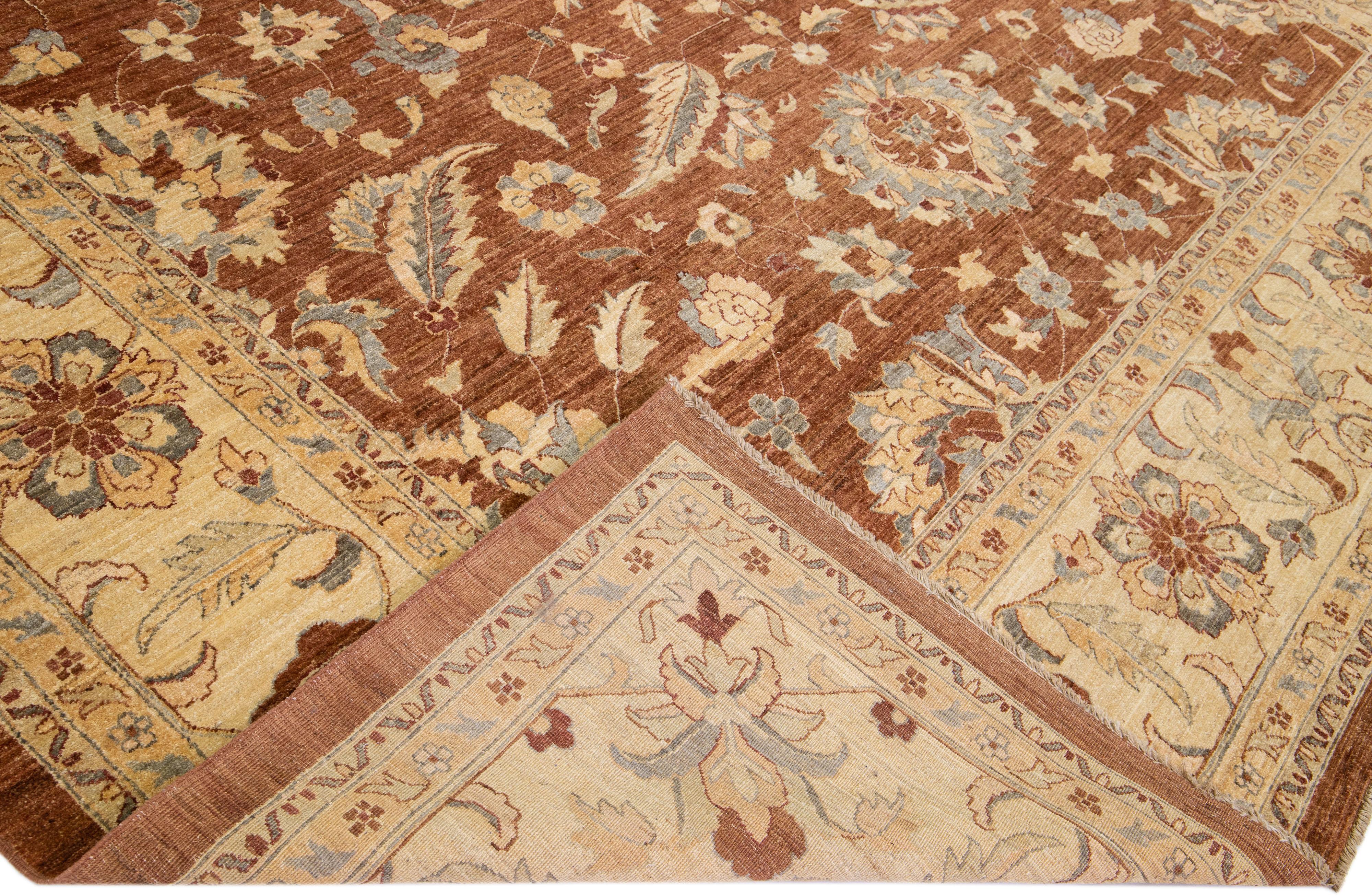 Schöner antiker, handgeknüpfter Wollteppich im Tabriz-Stil mit einem braunen Farbfeld. Dieses Stück hat einen beigen und blauen Akzent in einem prächtigen Blumenmuster.

Dieser Teppich misst 12'6