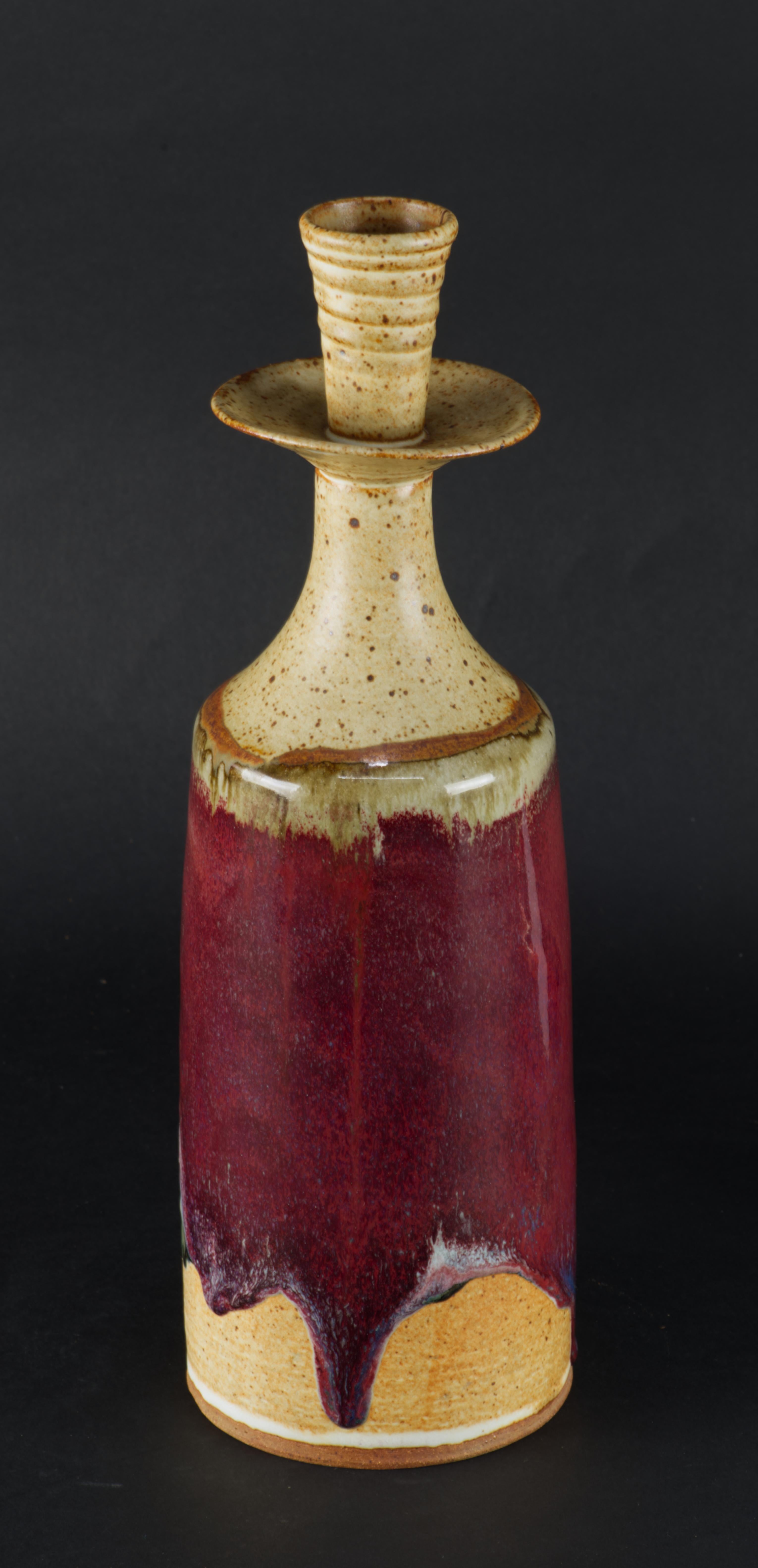  Der handgefertigte Keramik-Kerzenhalter hat eine schöne moderne Form und ist mit einer Kombination aus verschiedenen Glasuren verziert. Der Hals und der Korpus sind mit einer halbmatten, traditionellen braunen Salzglasur versehen. An der Schulter