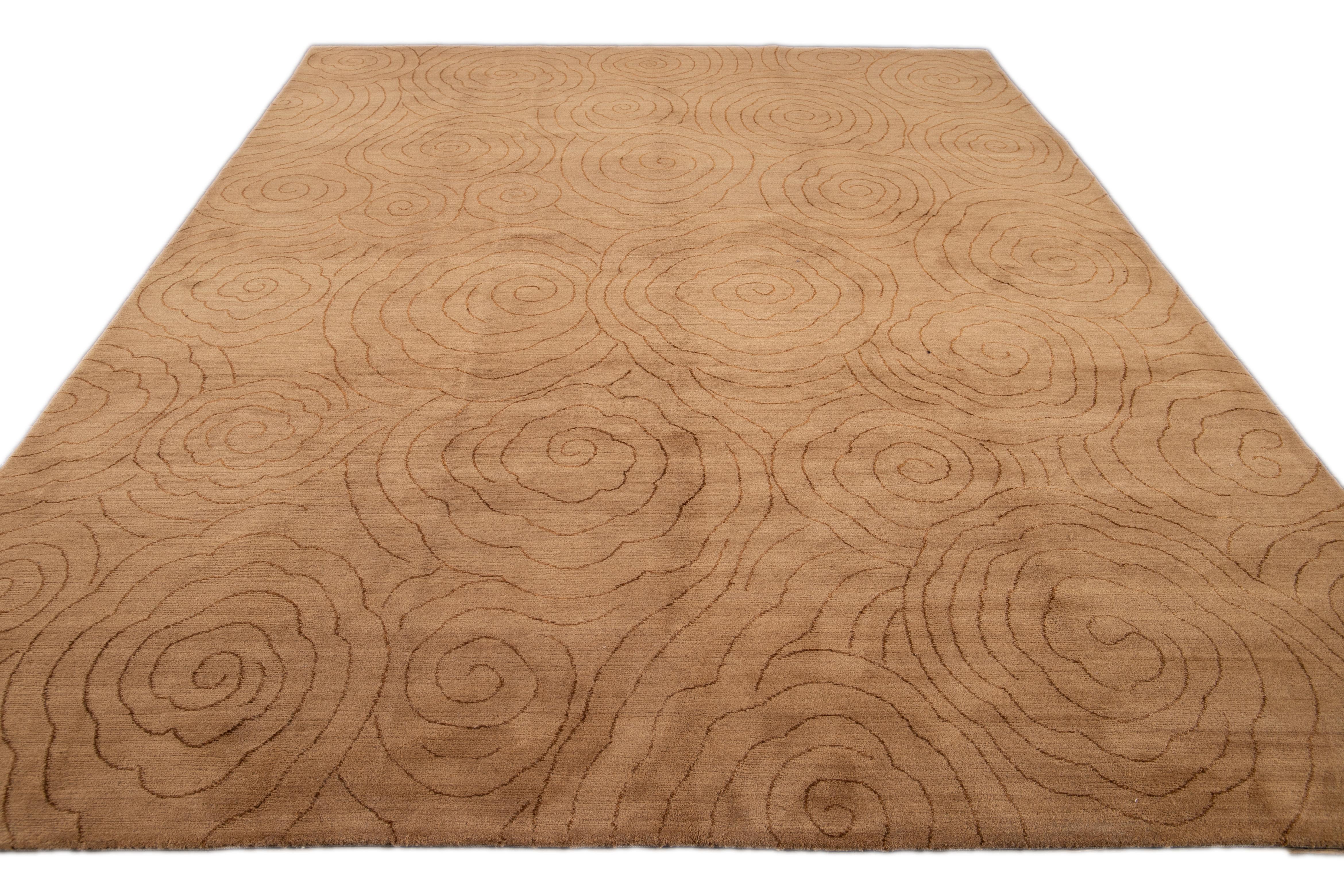 Dieser moderne Tufenkian Teppich zeigt einen neutralen, hellbraunen, abstrakten Hintergrund, der durch braune Akzente wunderbar zur Geltung kommt. Zusammen ergeben diese Elemente ein schickes und anspruchsvolles Gesamtdesign, das die Essenz des