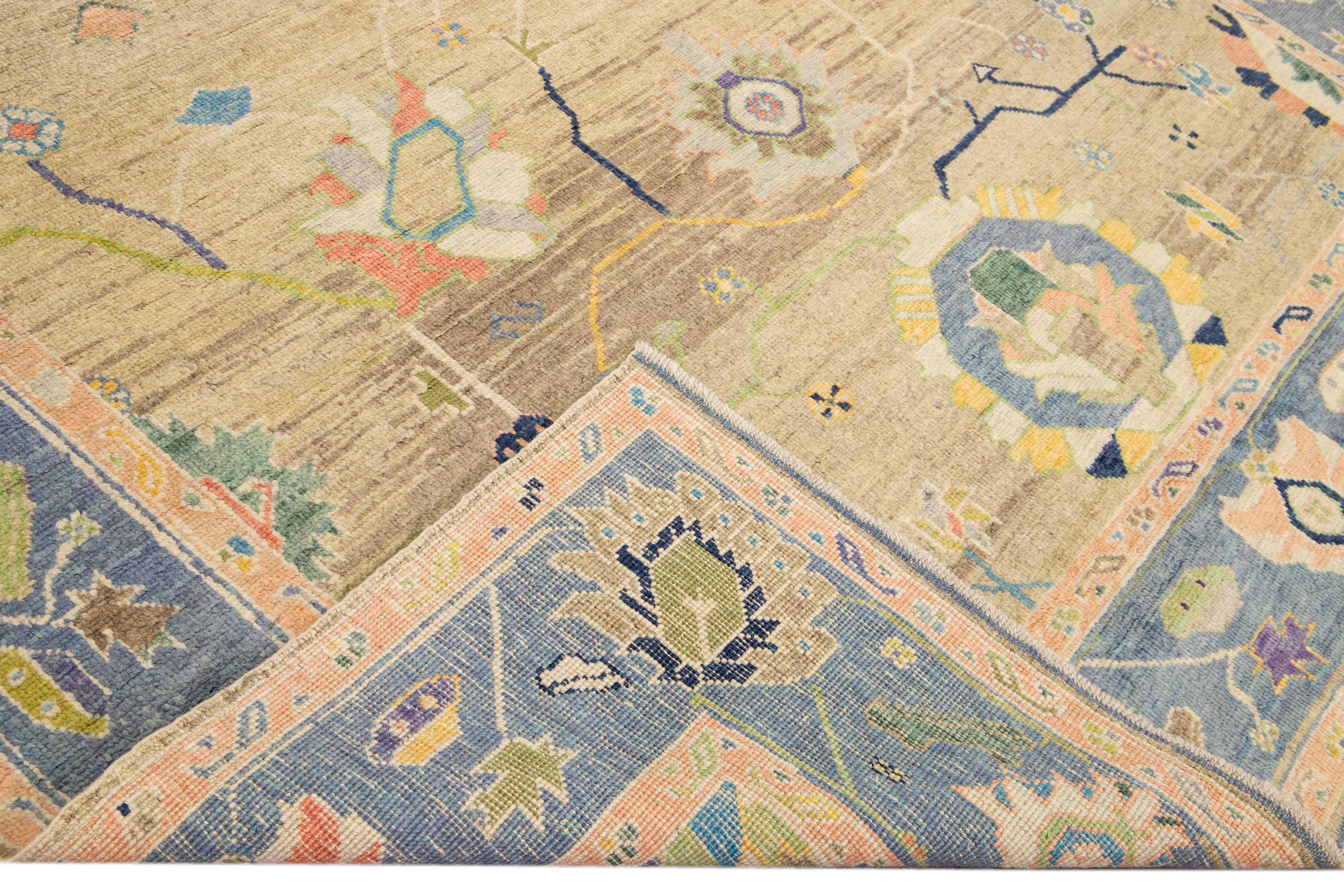 Beautiful modern Oushak hand-knotted wool rug with a Tan field. This Oushak rug has a navy blue frame and multicolor accents layout a gorgeous geometric floral pattern design. 

This rug measures: 9'1