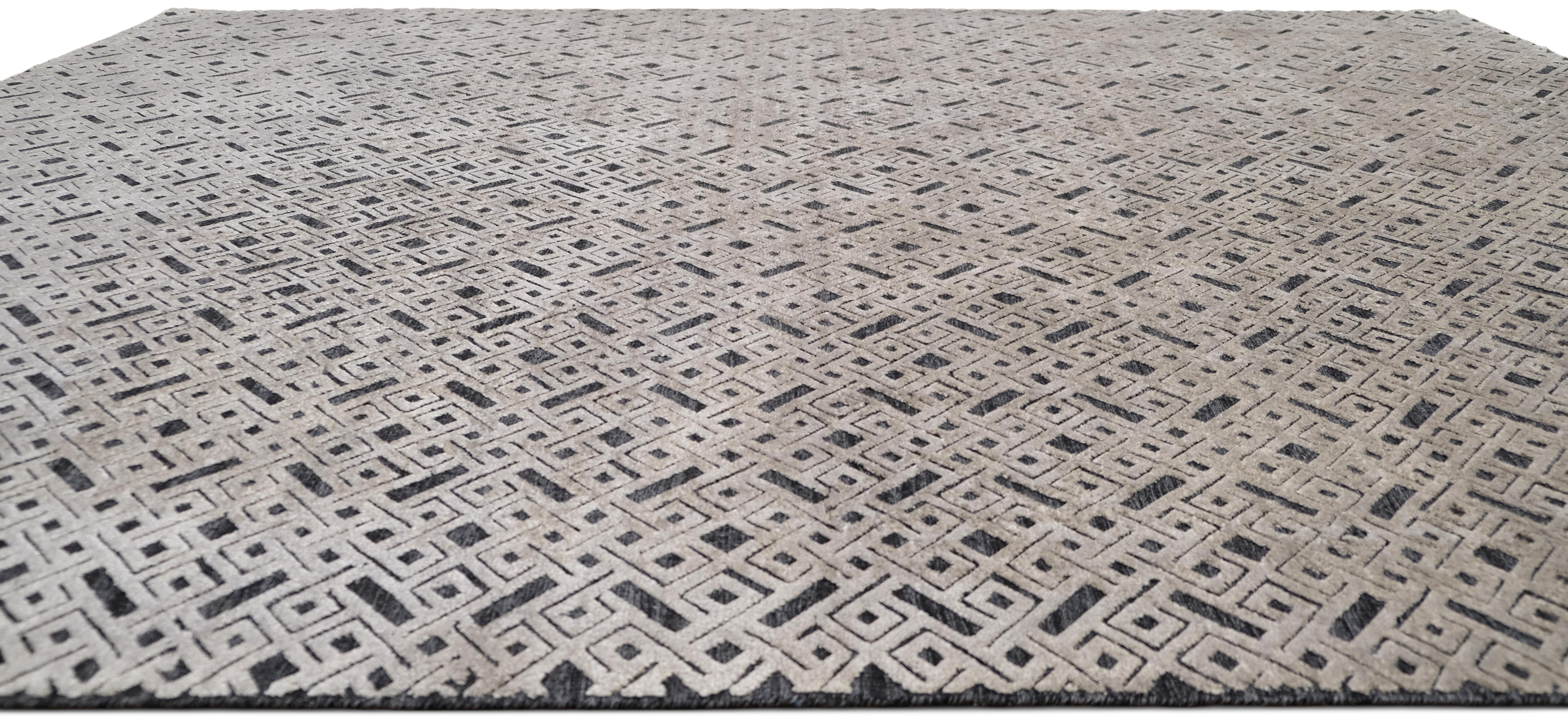 Eleva il tuo spazio con questo tappeto in lana e seta annodato a mano, caratterizzato da un intricato motivo geometrico a reticolo in una sofisticata palette di grigio e carbone. I motivi a incastro creano un effetto visivo ipnotico, fondendo