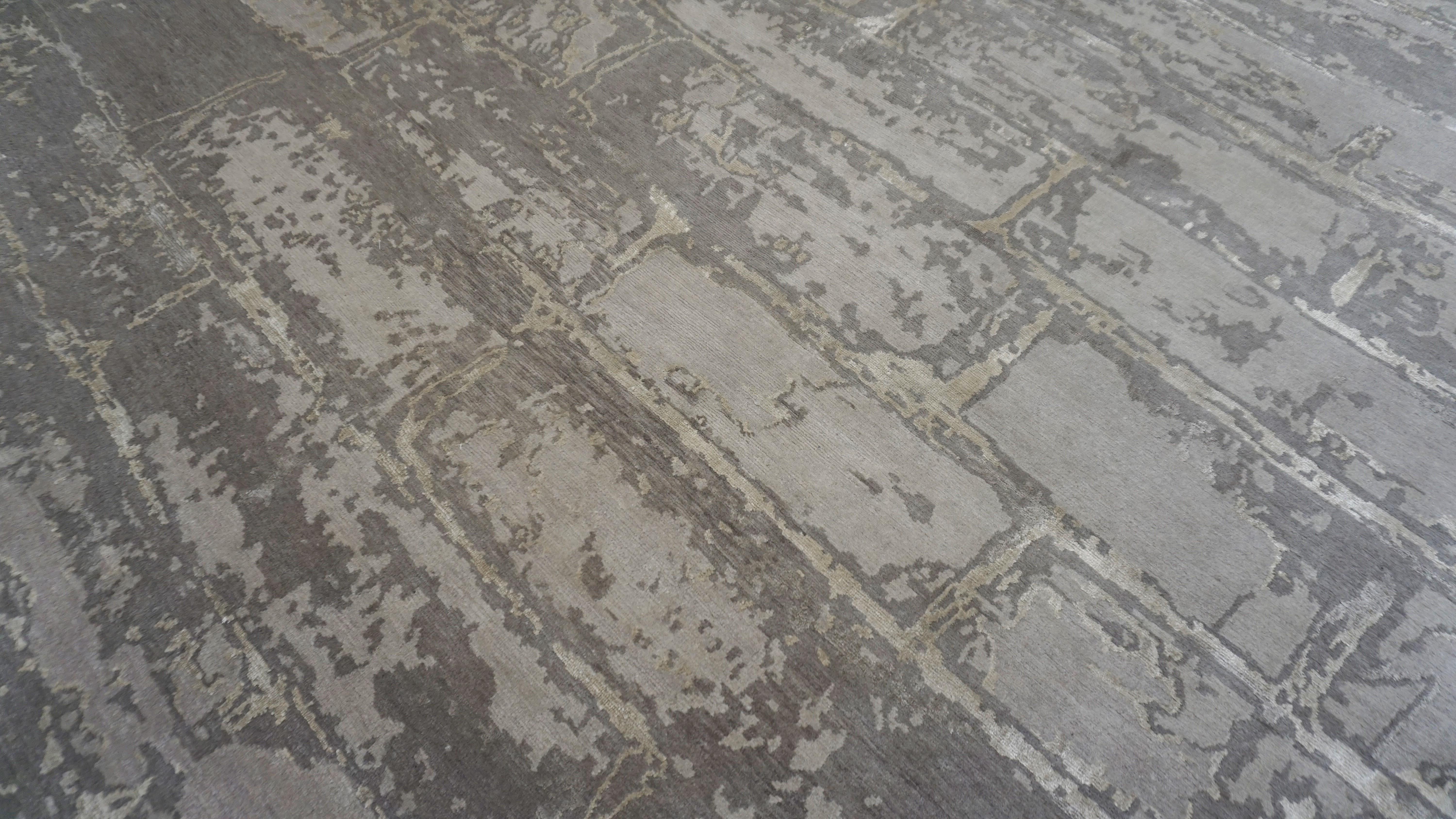 This hand-knotted wool and silk rug captures the rugged elegance of exposed architectural surfaces through a refined textile lens. Featuring a distressed brick motif, the design mimics the aged patina of a weathered stone wall or an urban façade