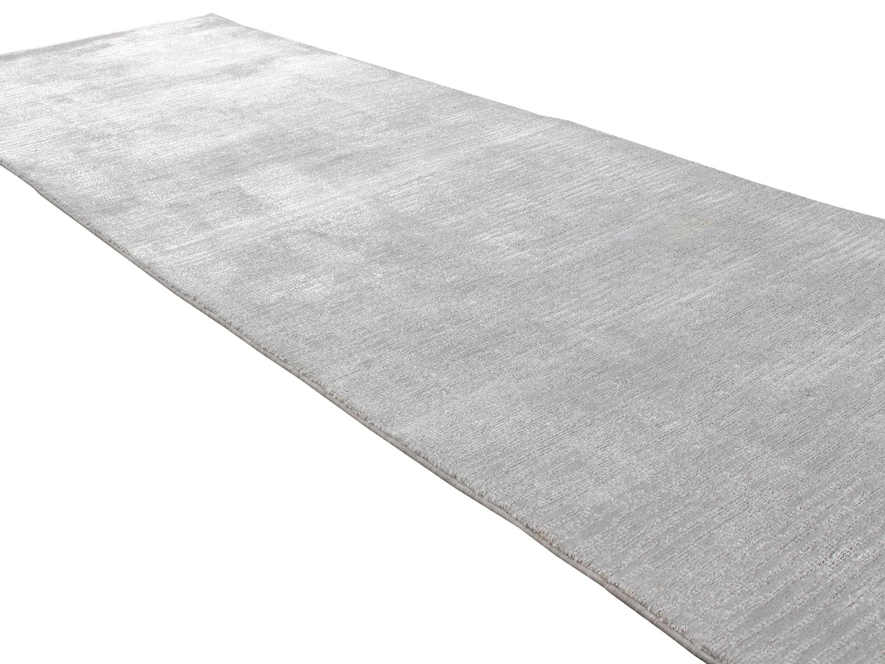 This is a beautiful, luxurious modern rug with a great deal of texture as it features a cut and loop design. It has a tone-on-tone silver/grey color and is comprised of bamboo silk. Custom options are available in any size and color.