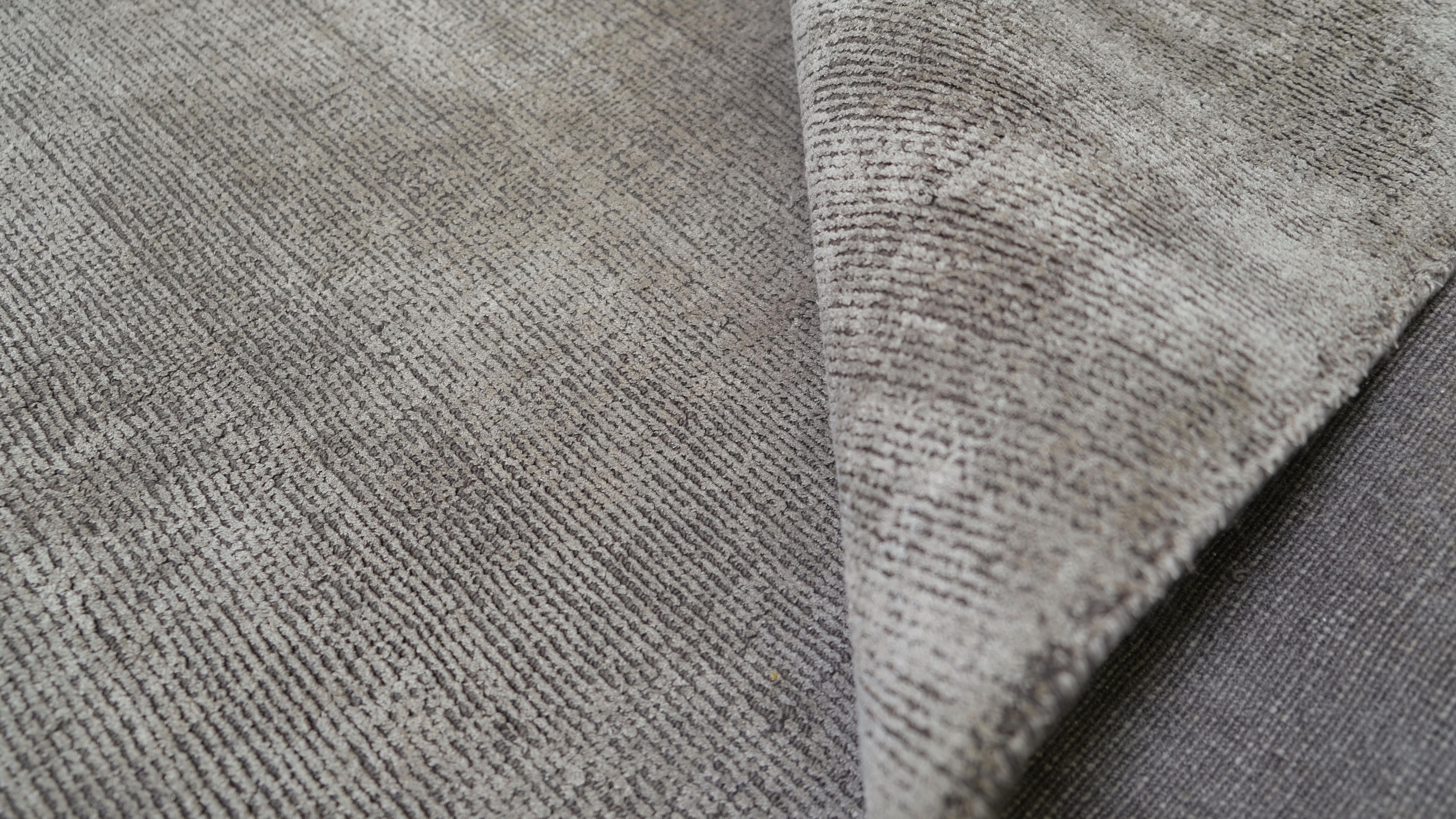 Introduce understated luxury to your space with this modern wool/silk rug. Featuring a sophisticated color, this rug embodies minimalism and versatility, making it an ideal choice for contemporary, industrial, or transitional interiors. Its subtle