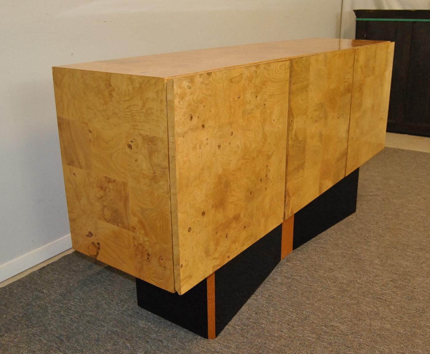 Modern patchwork inlay olivewood credenza by Thayer Coggin designed by Milo Baughman. Excellent original finish. Bow tie base with black laminate details. Two doors cover interior that has an adjustable shelf. There are four drawers. Two have