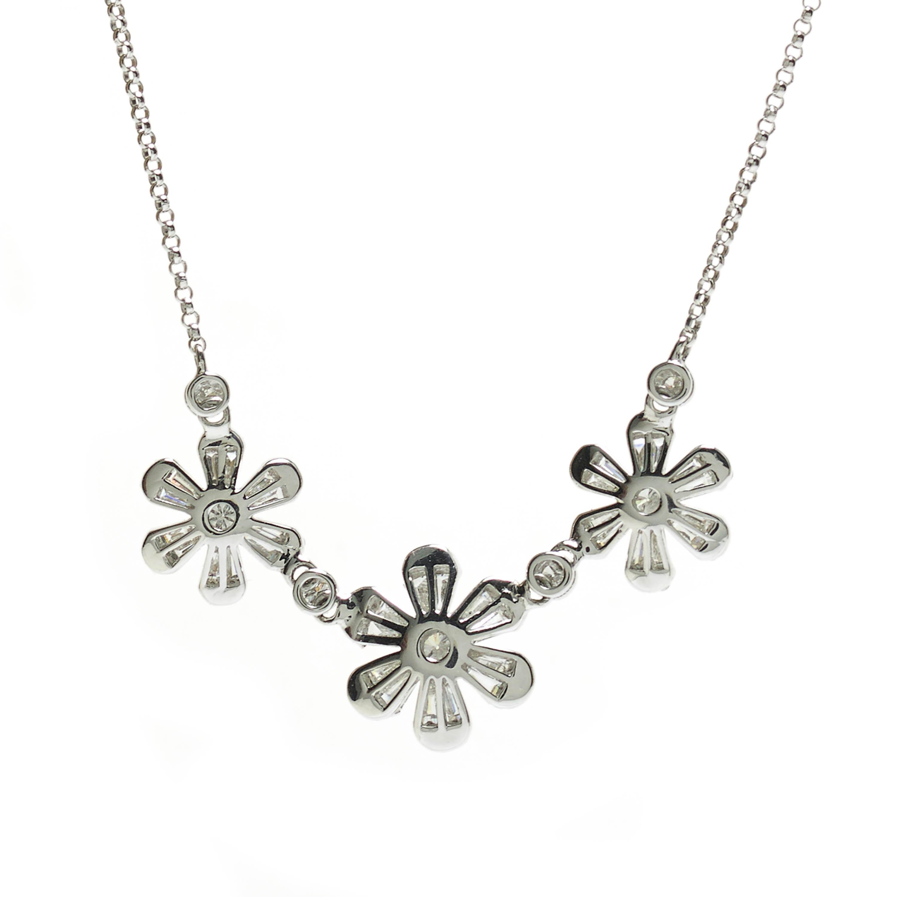 A modern diamond flower necklace, with three diamond set flowers, with a brilliant-cut diamond in each centre and two tapered baguette-cut diamonds and two round brilliant-cut diamonds in each petal, spaced with round brilliant-cut diamonds, in rub