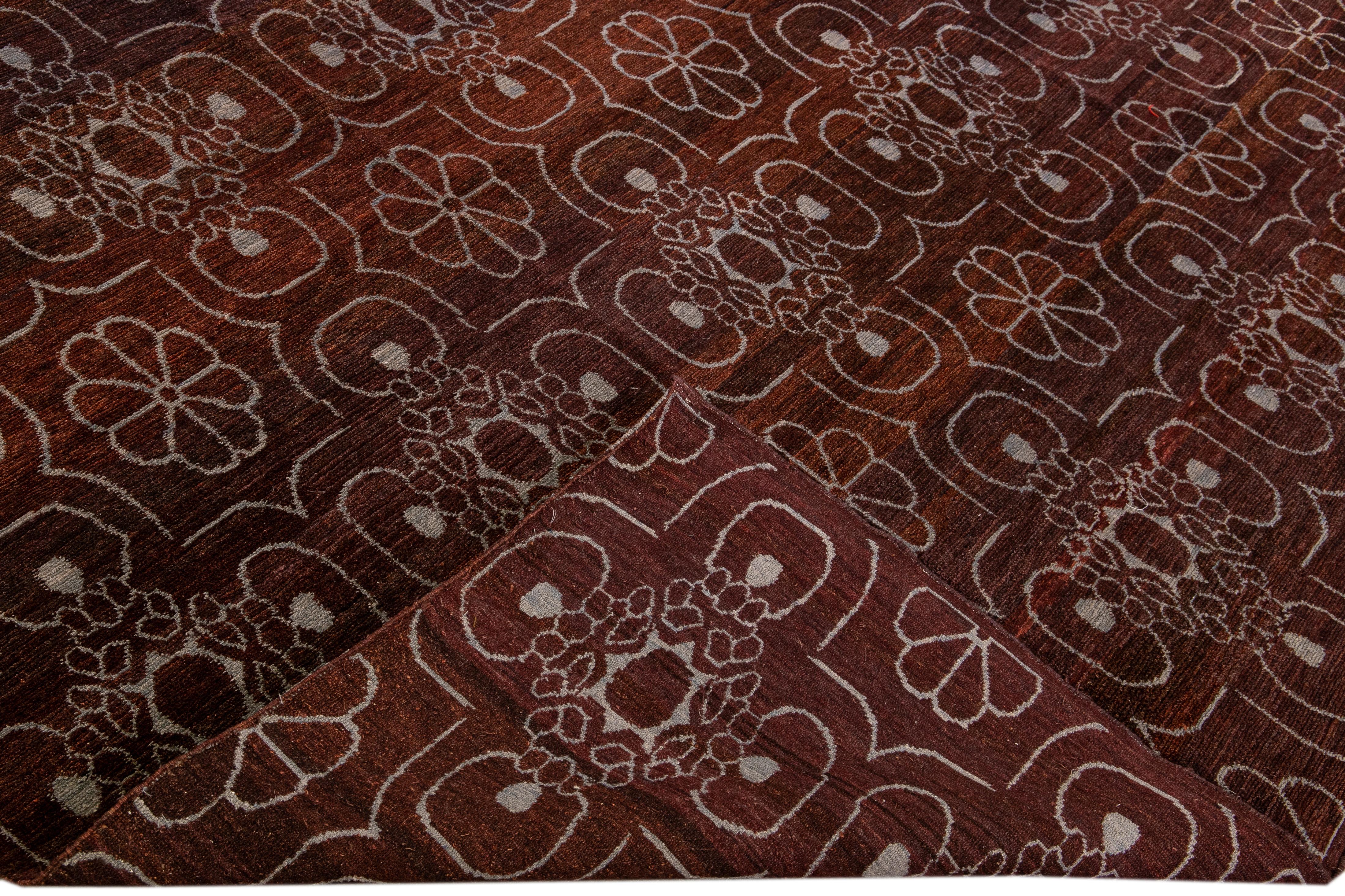 Bellissimo tappeto tibetano moderno annodato a mano in lana e seta con campo bordeaux. Questo tappeto tibetano presenta accenti grigi in uno splendido disegno arabesco all-over.

Questo tappeto misura 9'1