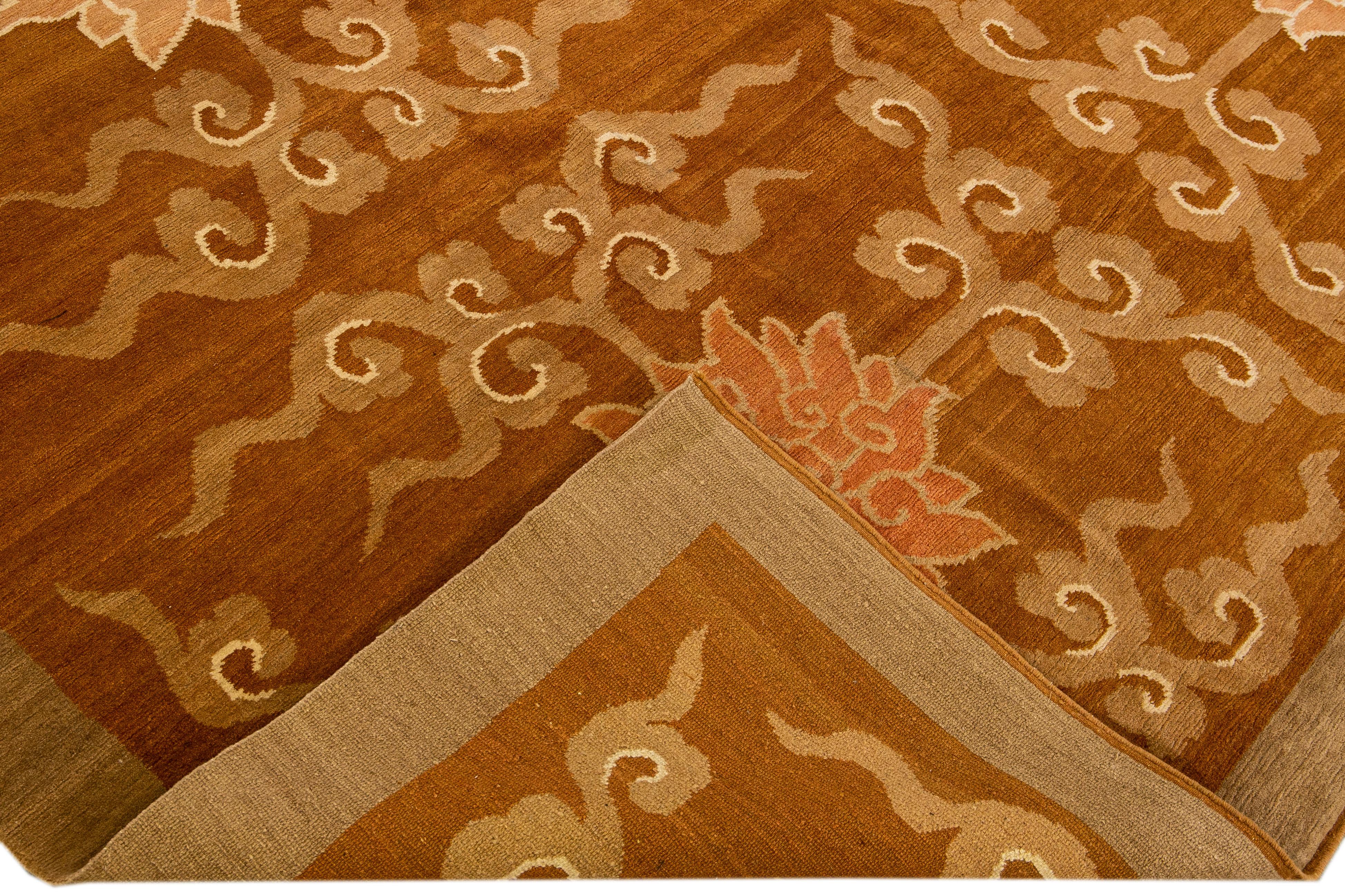 Beautiful modern Tibetan hand-knotted wool and silk rug with a brown field. This Tibetan rug has beige and peach accents in a gorgeous all-over lotus flower pattern design.

This rug measures 8'10