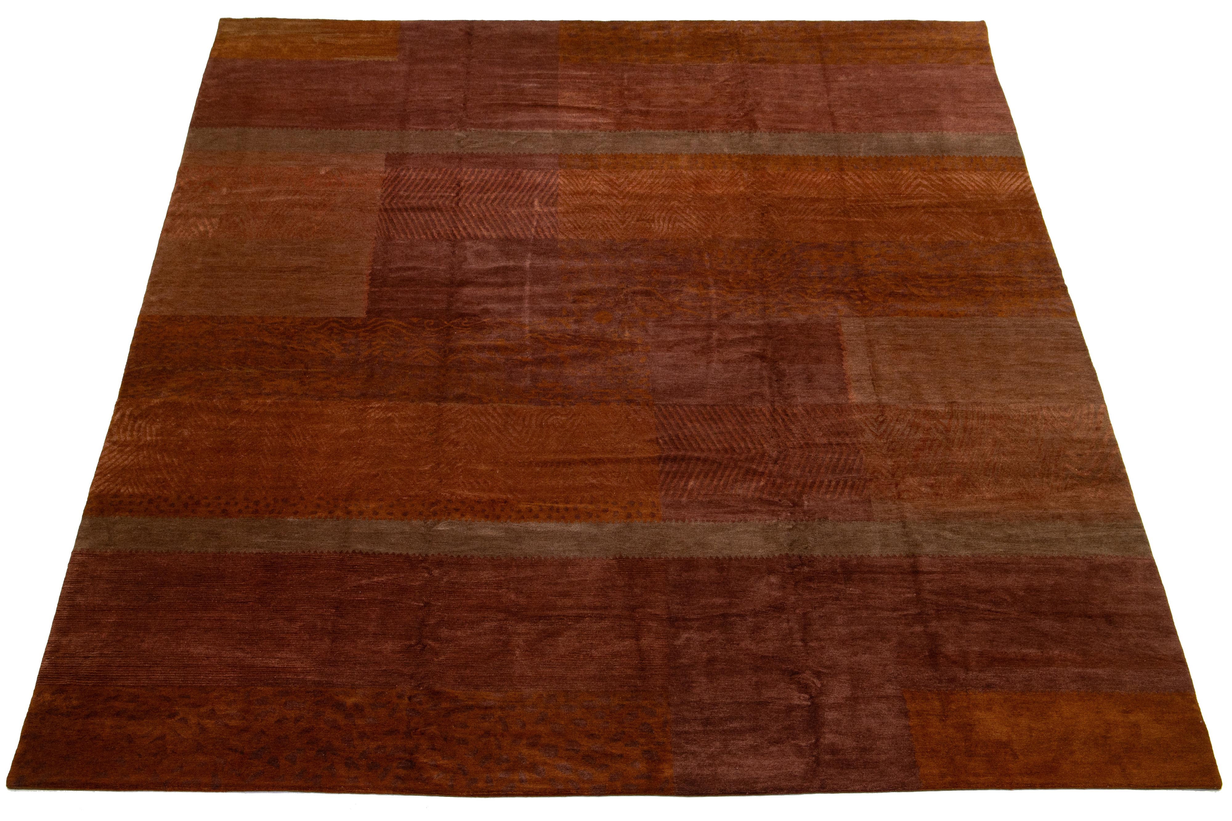 This modern Tibetan rug has a rust-colored field with orange and brown accents, creating a chic and sophisticated overall geometric design that reflects the essence of modernism in the 21st century.

This rug measures 13'5