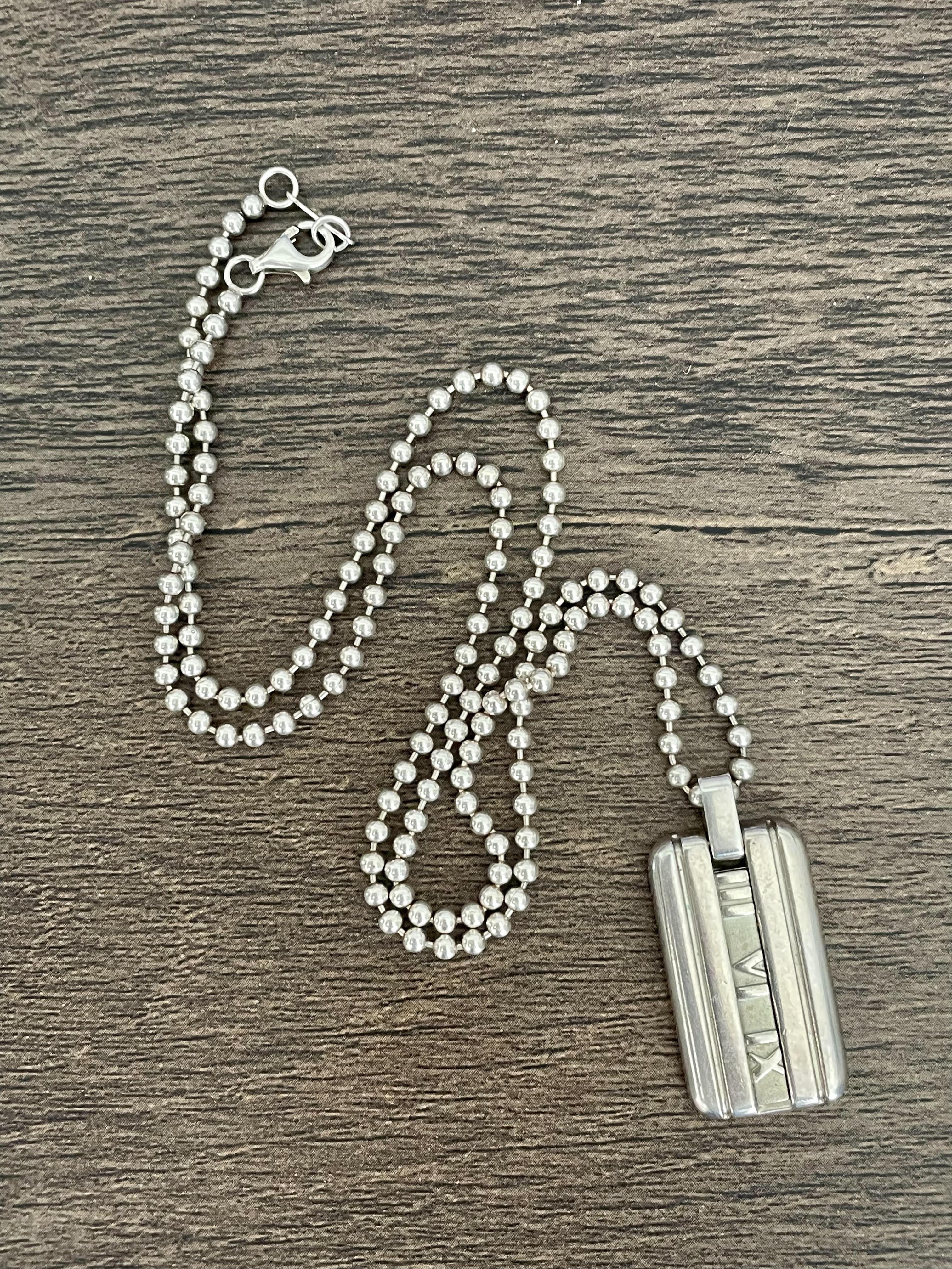 This is a classic modern Tiffany & Company dog tag pendant and bead link chain.  The closure is a great working condition lobster claw.

Stamps:  
Pendant: ATLAS @ 2003 TIFFANY 7 CO. 925
Chain: TIFFANY & CO. 925

Pendant measurement:  1