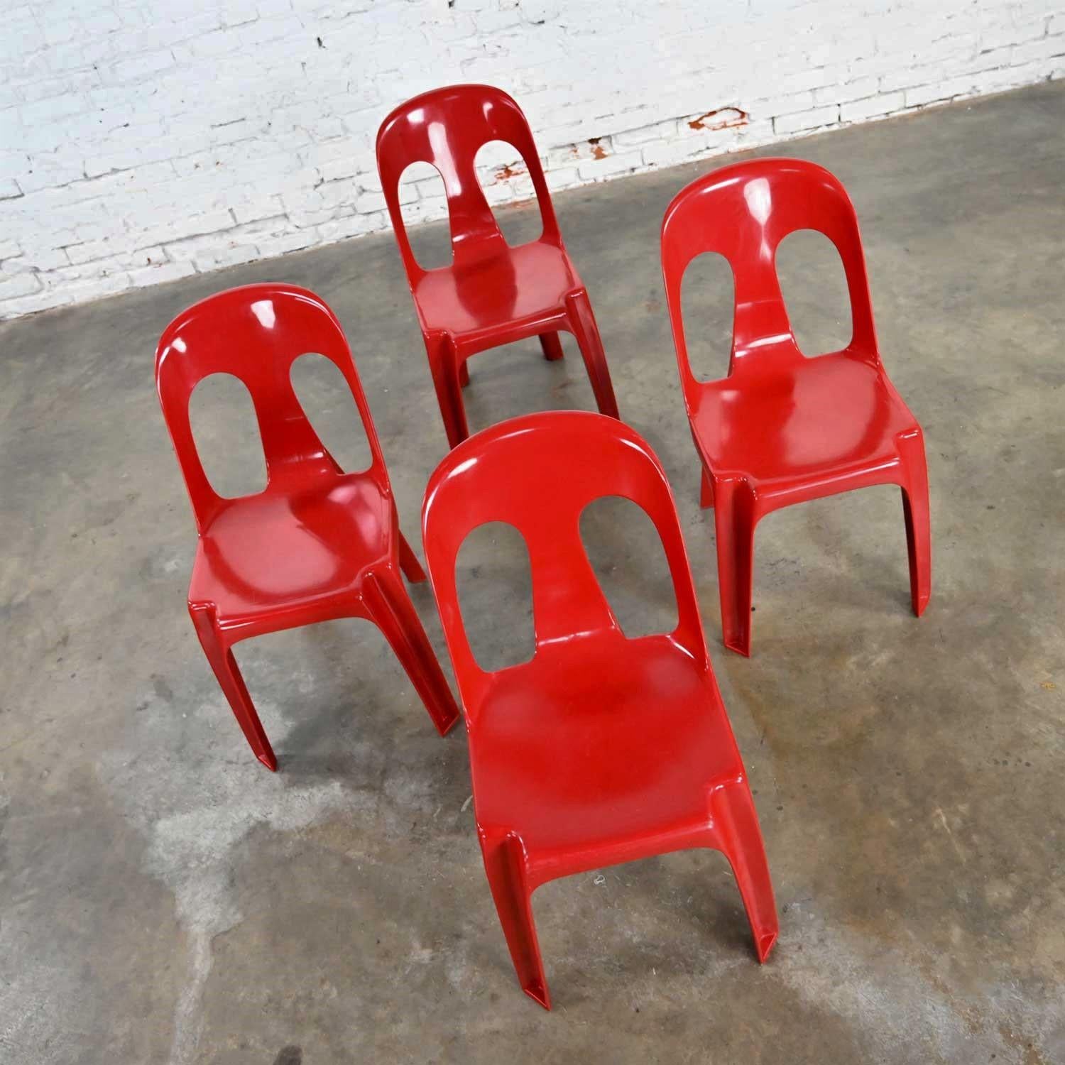 Gorgeous modern to post-modern set of four red plastic stacking chairs by Henry Massonnet. Beautiful condition, keeping in mind that these are vintage and not new so will have signs of use and wear. There are scuffs to the plastic from use but no
