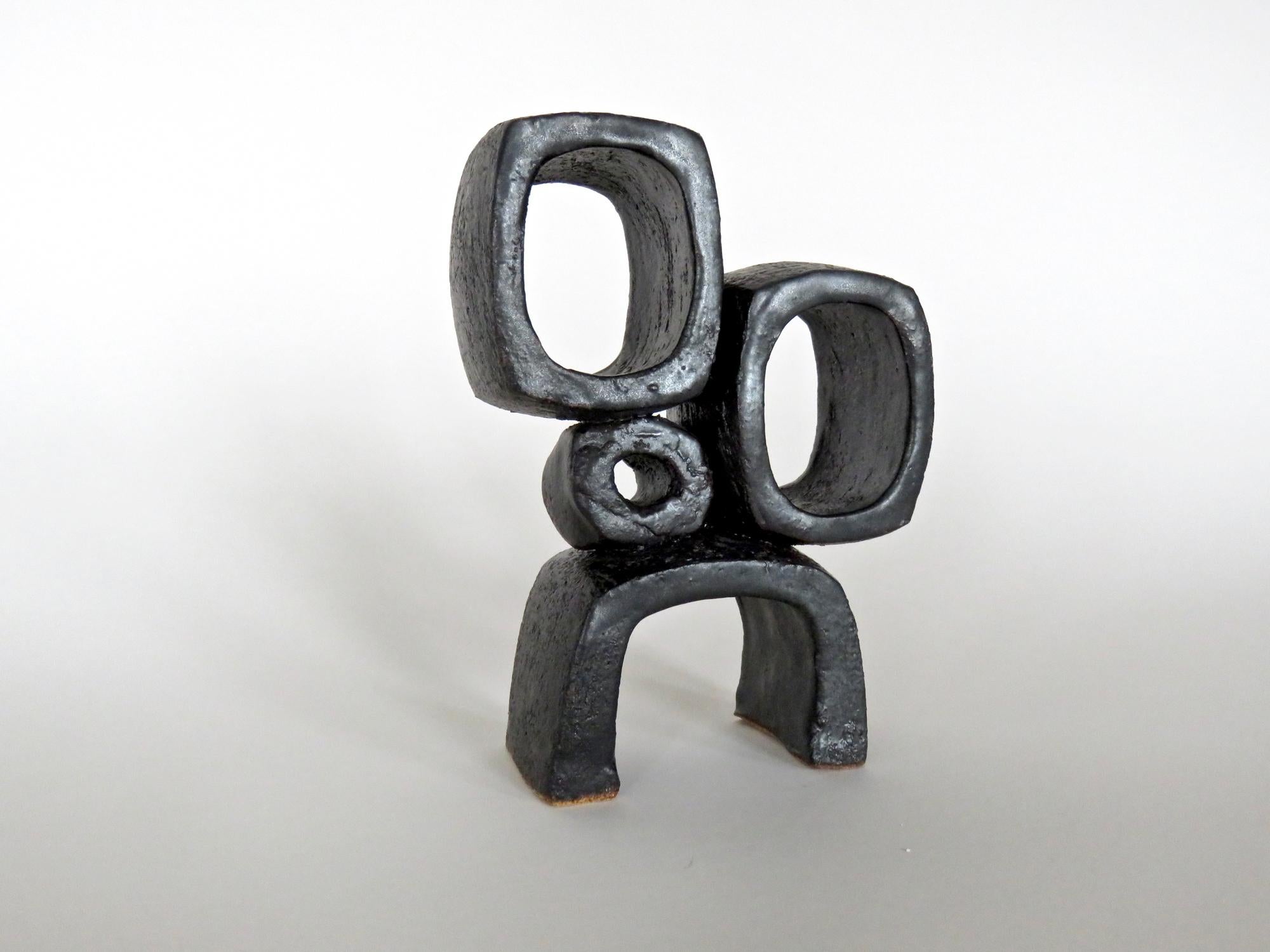 Modern TOTEM, metallic black ceramic sculpture with 2 rectangular rings and 1 small knot of clay on a rectangular, arc'd foot. This ceramic sculpture is one in a series of 