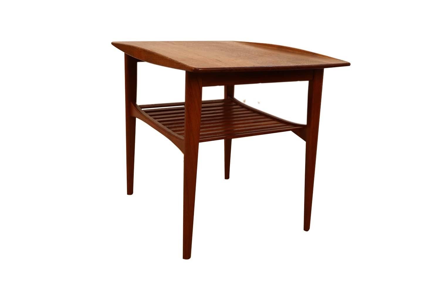 Solid Teak model FD510 Mid-Century Modern imported by John Stuart side table designed by Tove and Edvard Kindt-Larsen and manufactured by France & Daverkosen. A solid teak rectangular table top with a graceful bowed side rail and features an open