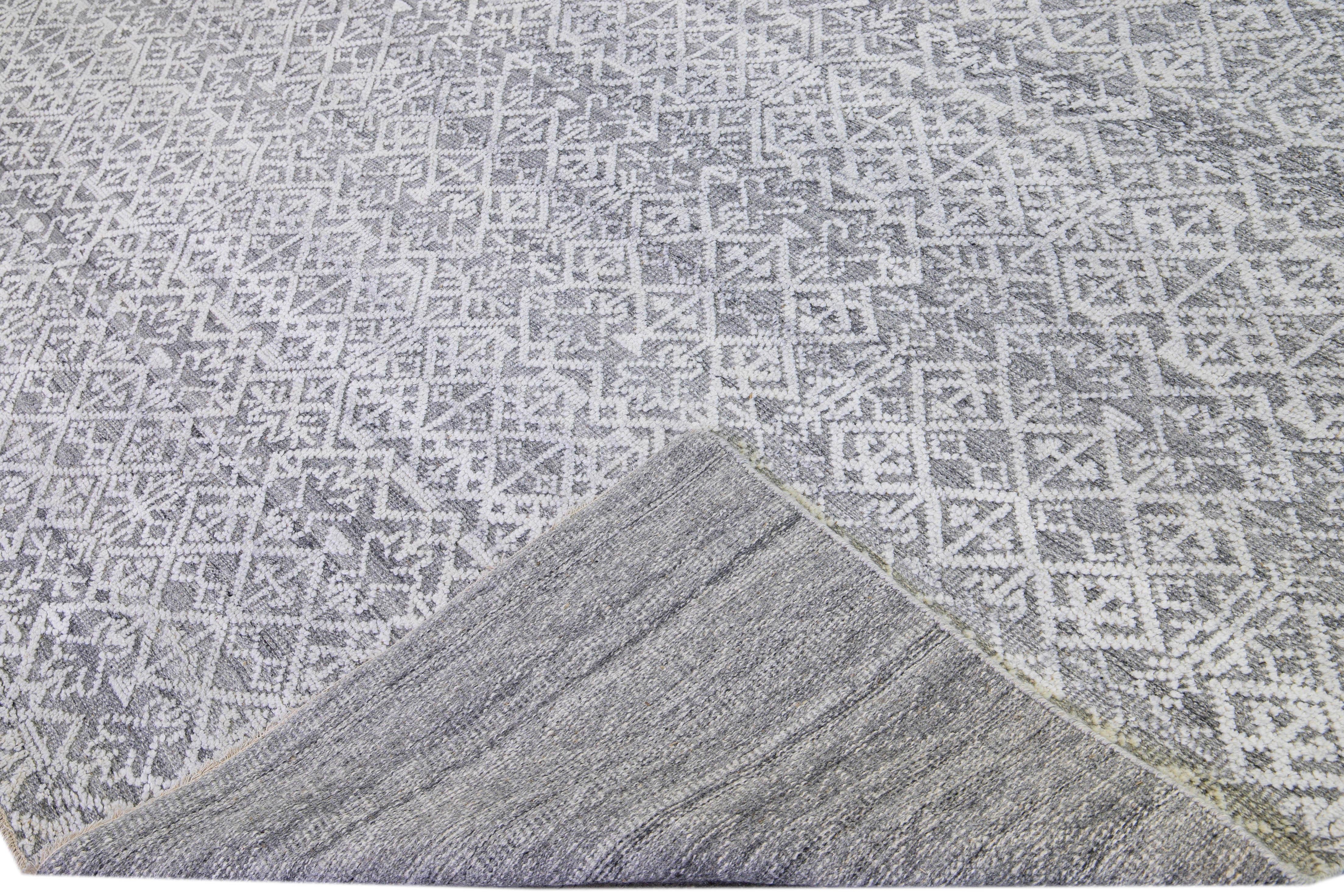 Beautiful modern hand-knotted wool rug with a gray field. This Transitional rug has an Ivory accent to create a modern, geometric pattern design with a mid-century look. 

This rug measures: 12' x 14'9