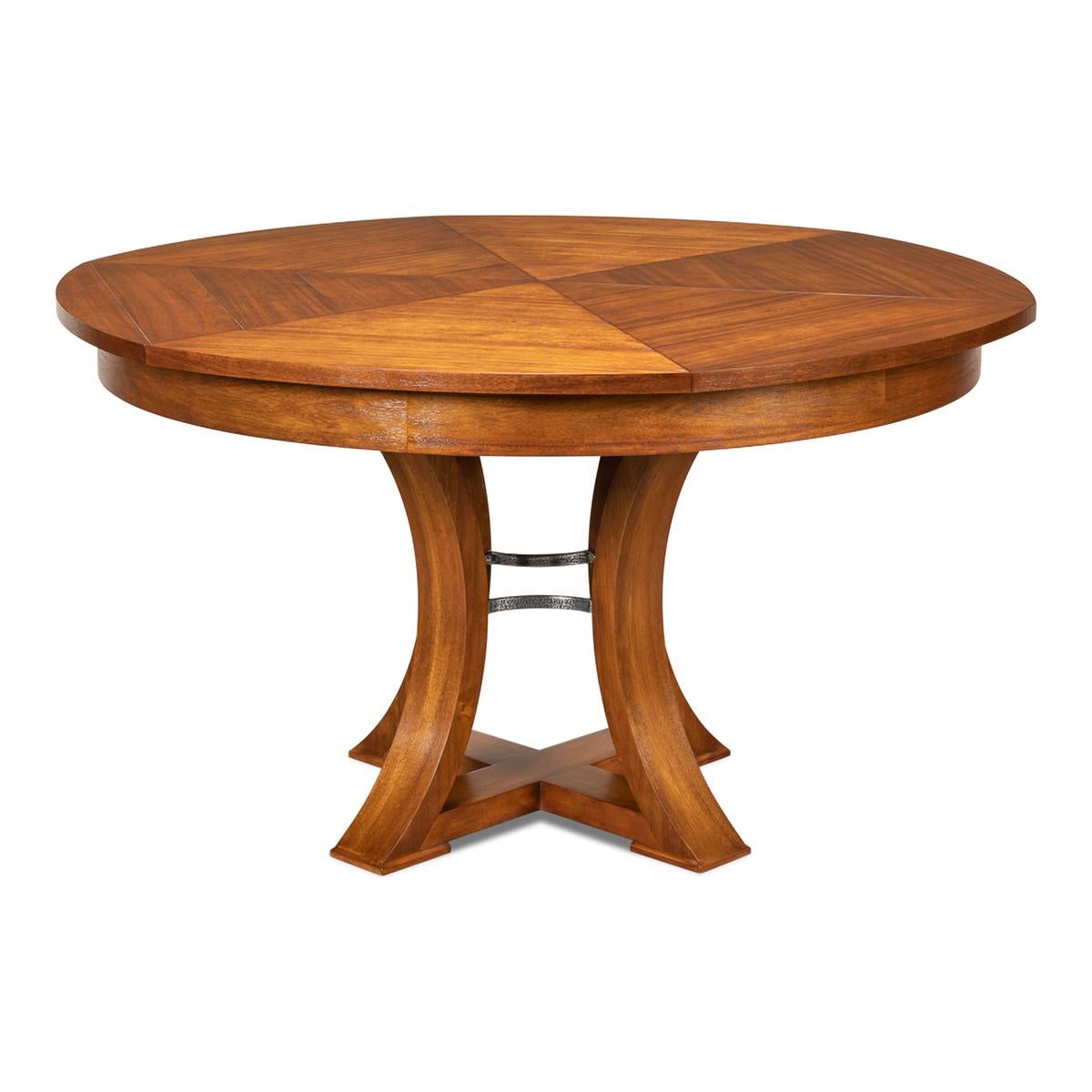 A modern transitional style round extending dining room table. Warm acacia wood top in our aged tobacco finish with iron supports to the simple geometric form base. The table opens and extends to 70