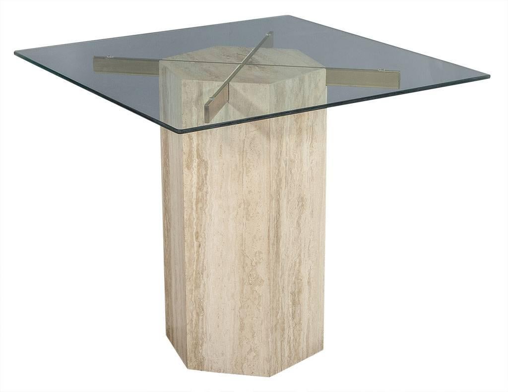 This vintage breakfast table is definitely unique. Composed of a polygon Travertine marble base inset with solid brass supports and a glass top it has just the right amount of contrast in texture. Perfect for a distinctly styled home.