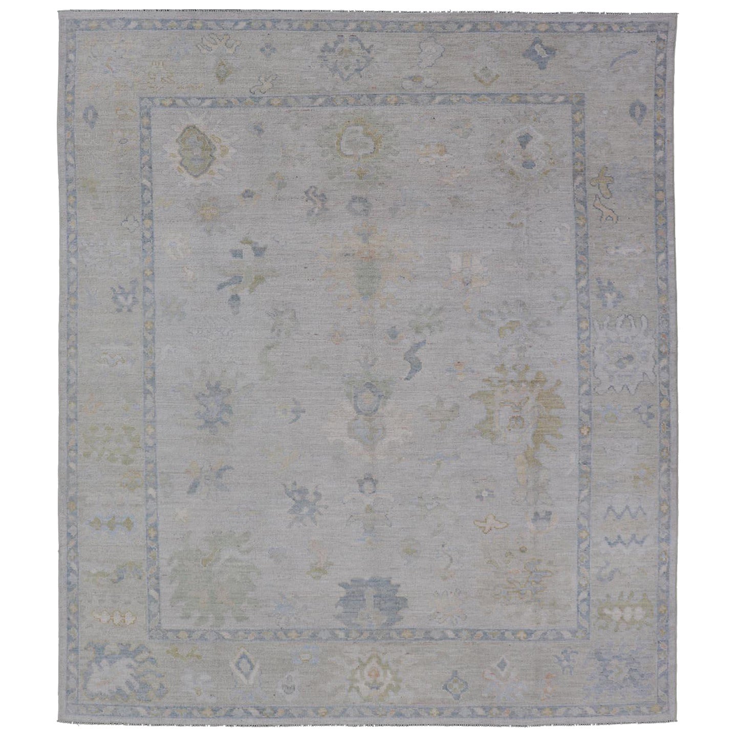 Oushak tribale moderno con bordo color crema e sfondo grigio-blu chiaro