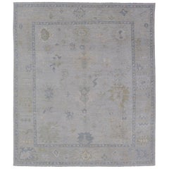 Oushak tribale moderno con bordo color crema e sfondo grigio-blu chiaro