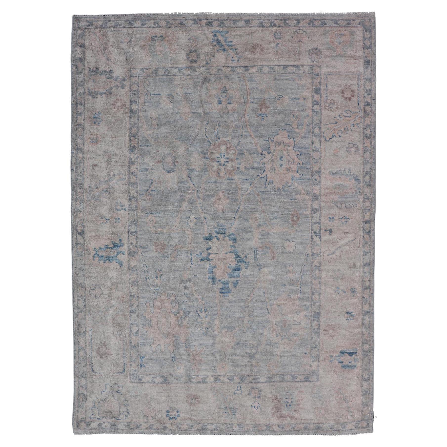Modern Tribal Oushak with a Cream Border and Light Gray-Blue Background For Sale