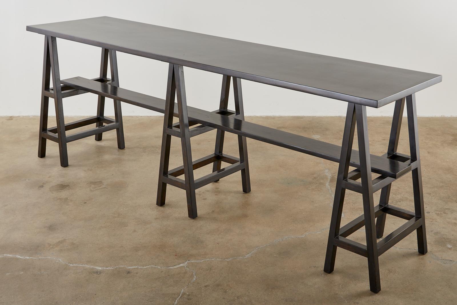 Distinctive modern style trestle table or bar constructed from three sawhorse style pedestals. The long table could be used as a counter height bar (36 inches high) or a large console table. The height makes it comfortable to stand or sit with a