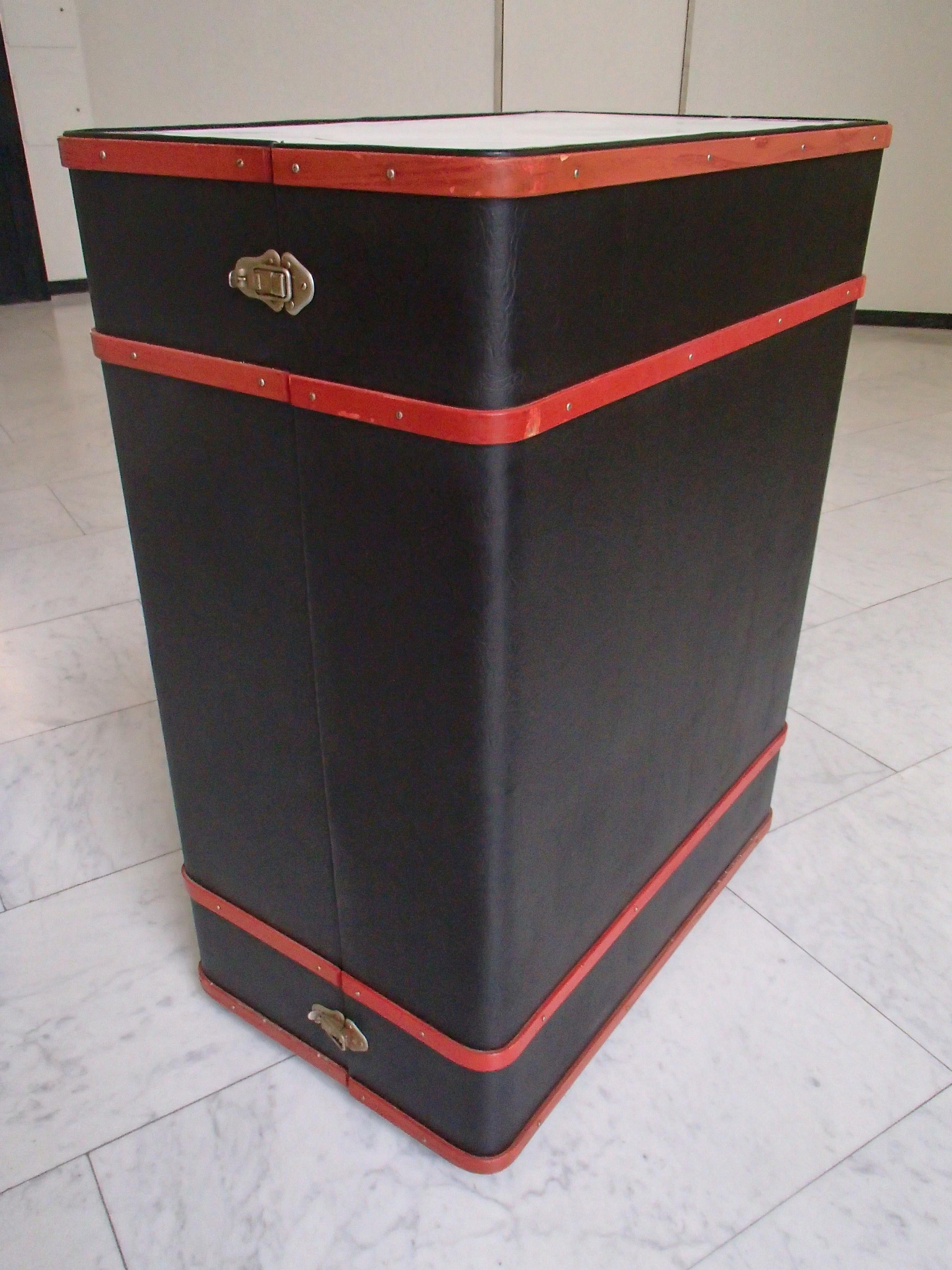 Moderne Kofferraumleiste schwarz und rot mit Waschbecken innen auf Rädern.