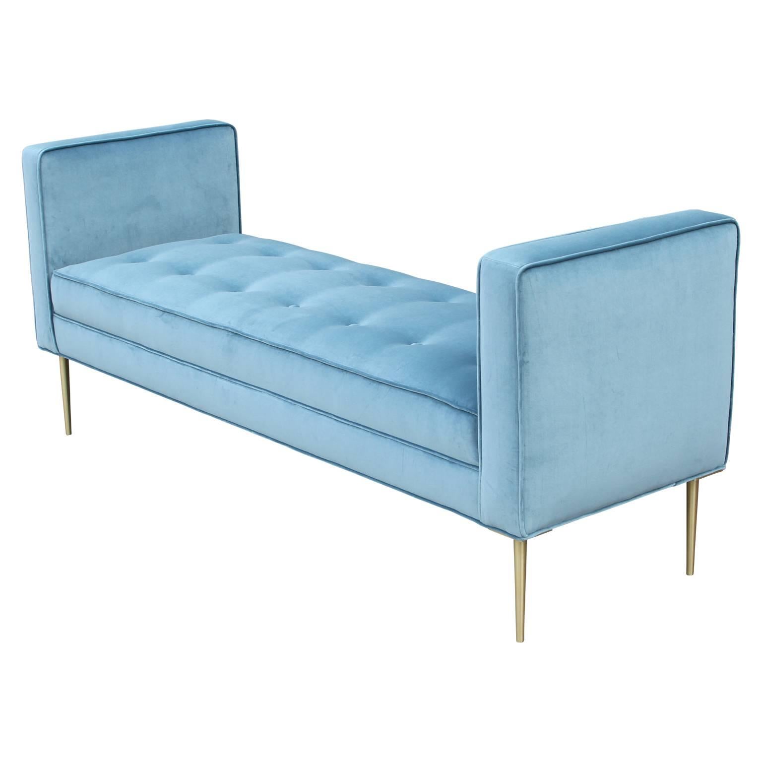 Beautiful armed bench upholstered in a luscious periwinkle blue velvet with brushed brass legs.