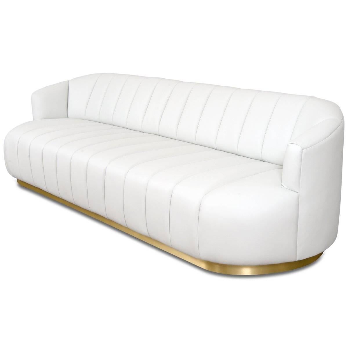 Introducing the Avalon Sofa in faux leather. This bold sofa features top to bottom channel tufting in the front and a smooth back. A shiny brass veneer toe kick adds a touch of cool metal contrast to this trendy sofa and a slightly pitched back adds
