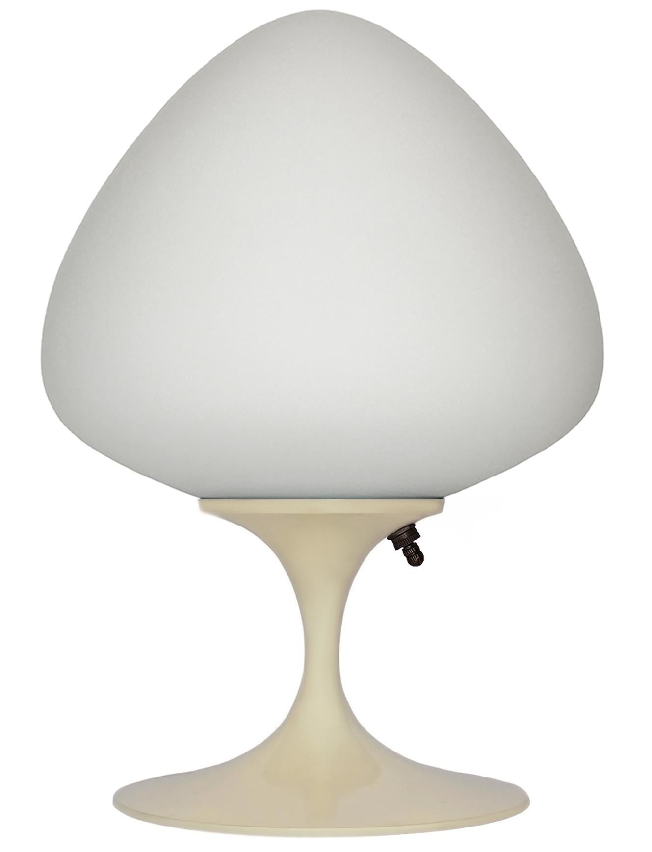 A gorgeous tulip form table lamp, desk lamp or bedside lamp. It features a cream beige cast aluminum base with mouth blown frosted white glass shade in an acorn form. It takes one standard bulb up to 100 watts.

These retro lamps work with all
