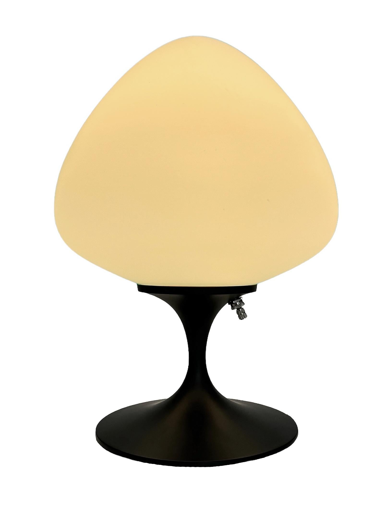 A gorgeous tulip form table lamp, desk lamp or bedside lamp. It features a satin black cast aluminum base with mouth blown frosted white glass shade in an acorn form. It takes one standard bulb up to 100 watts.