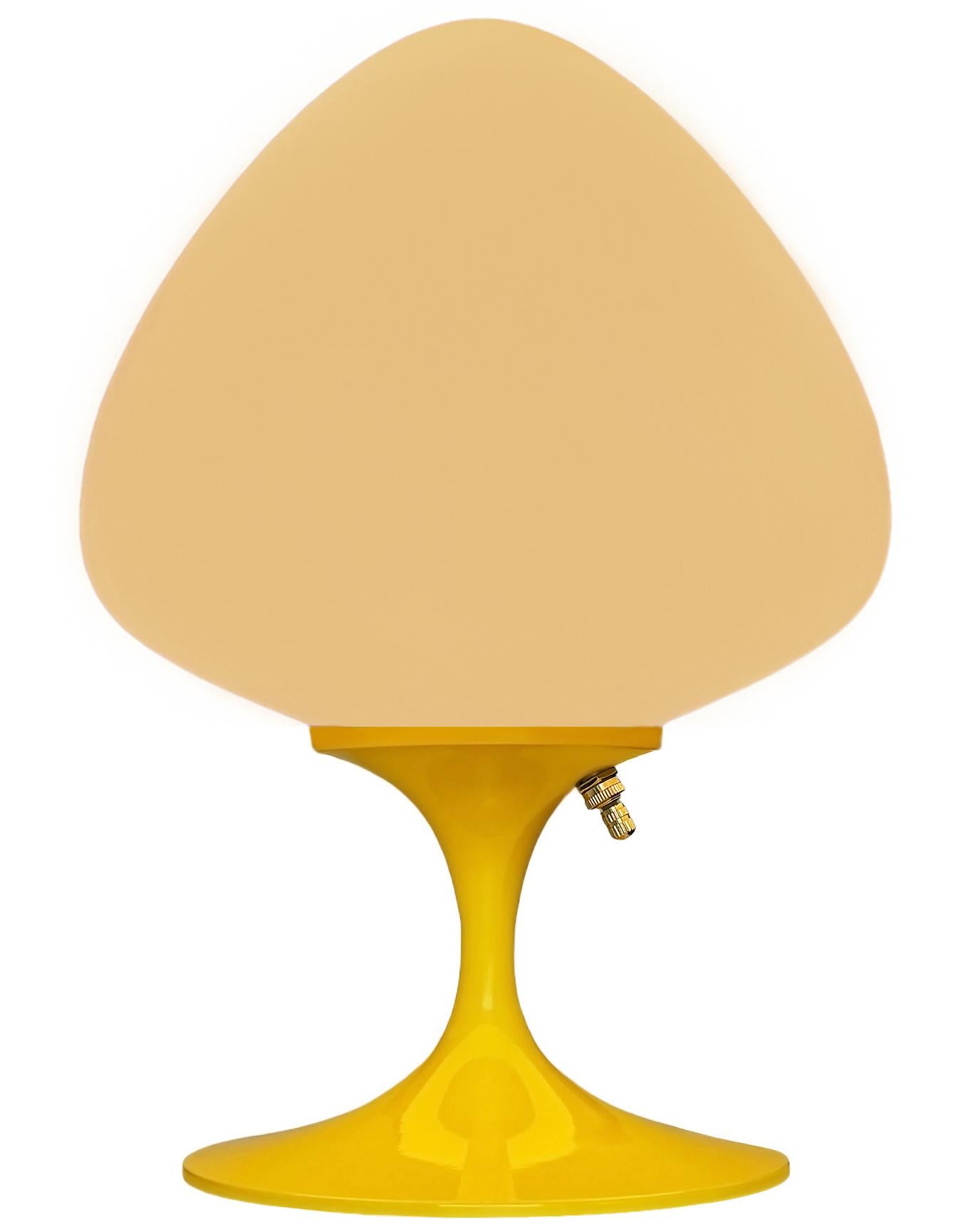 Une magnifique lampe de table, de bureau ou de chevet en forme de tulipe. Whiting se caractérise par une base en fonte d'aluminium jaune clair et un abat-jour en verre blanc dépoli soufflé à la bouche en forme de gland. Elle accepte une ampoule