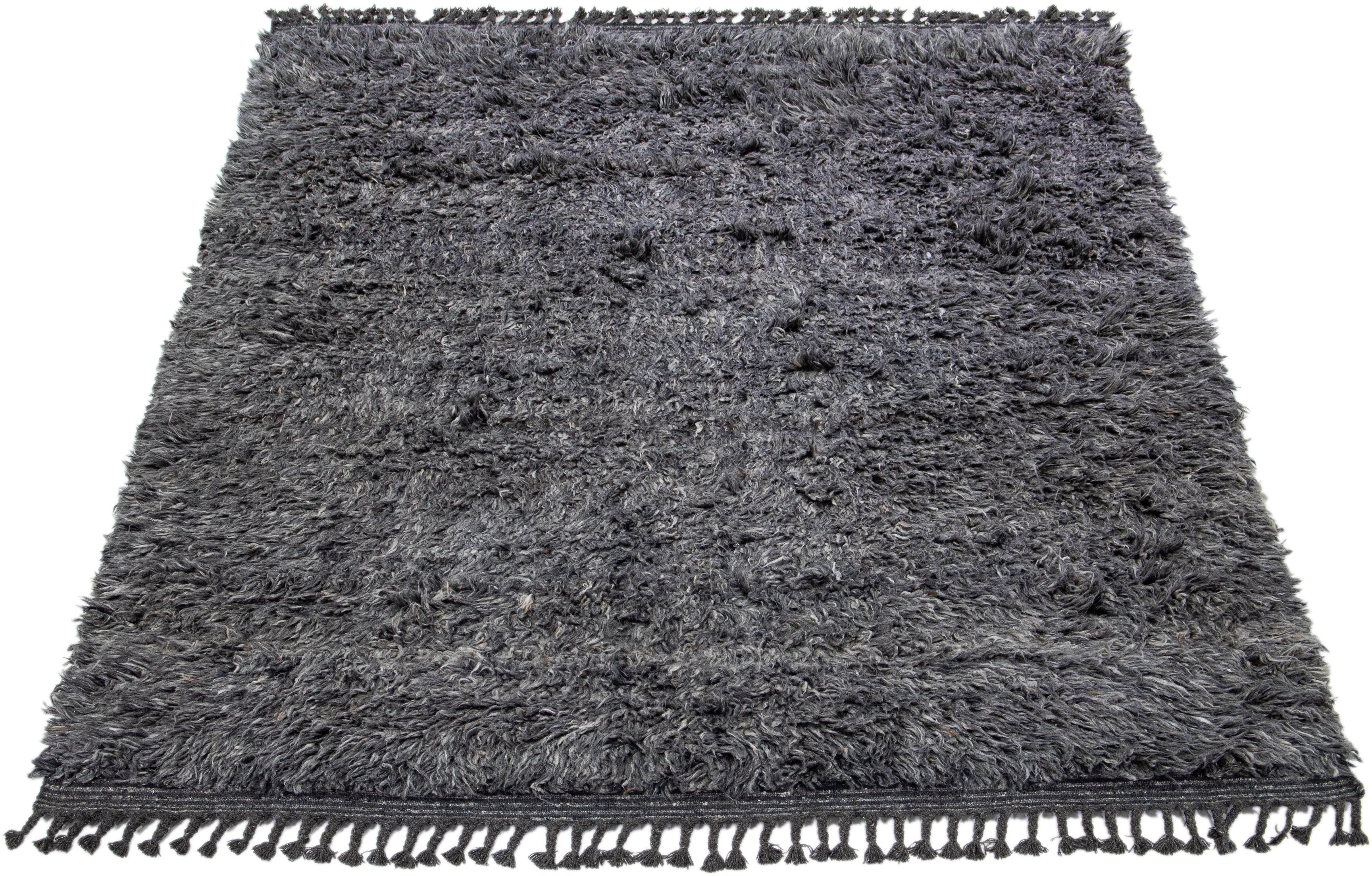 This hand-knotted rug is made from organic wool and has a chic Moroccan style. It showcases an enthralling background in tones of gray and charcoal.

This rug measures 8'2' x 10'3